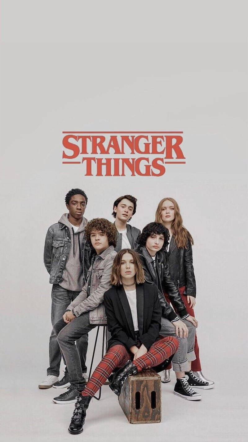 Netflix 桌布 壁紙 — 六位年輕演員身穿1980年代風格服裝，在純色背景前擺姿勢，上方有「Stranger Things」標誌。