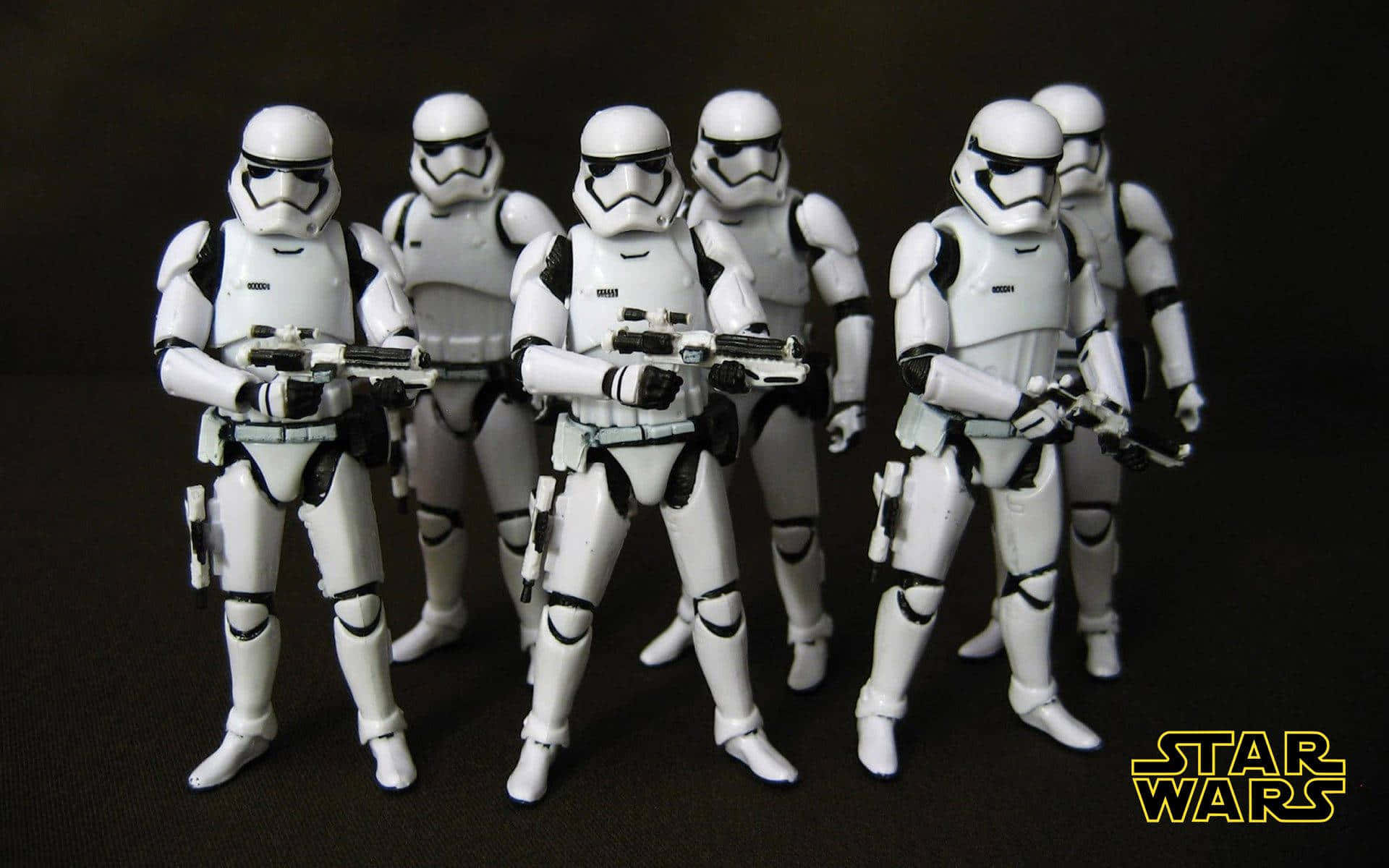 First Order 桌布 壁紙 — 六個星際大戰風暴兵可動人偶排成隊形，在黑暗背景下手持爆能槍。