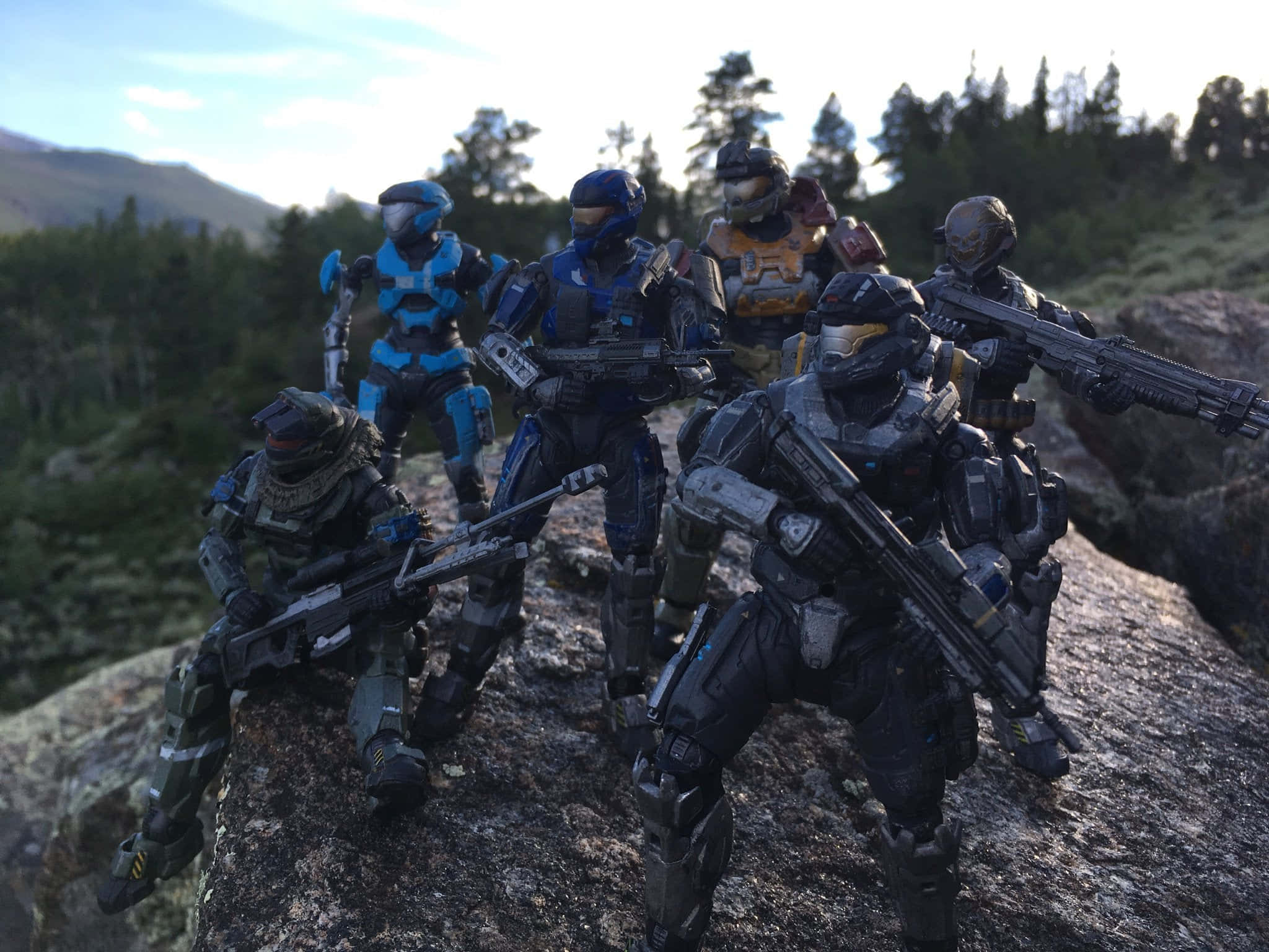 Noble Team 桌布 壁紙 — 六個身穿戰鬥裝備的Halo Spartan動作人偶在岩石露頭上，以森林覆蓋的山脈為背景擺出姿勢。