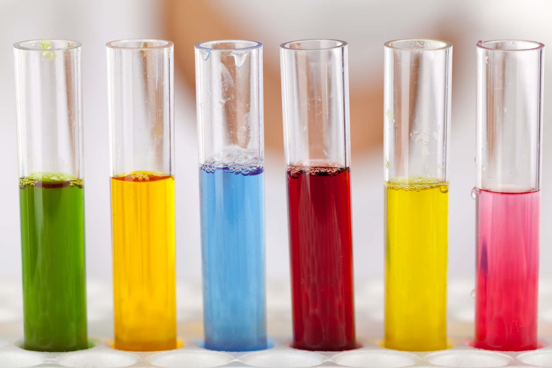 Chemistry 桌布 壁紙 — 六支裝滿鮮艷彩色液體的試管整齊排列在實驗室枱面上。