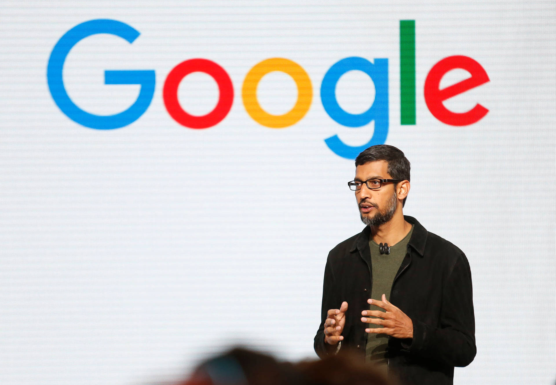 男子在Google活動中發言，背後有標誌。