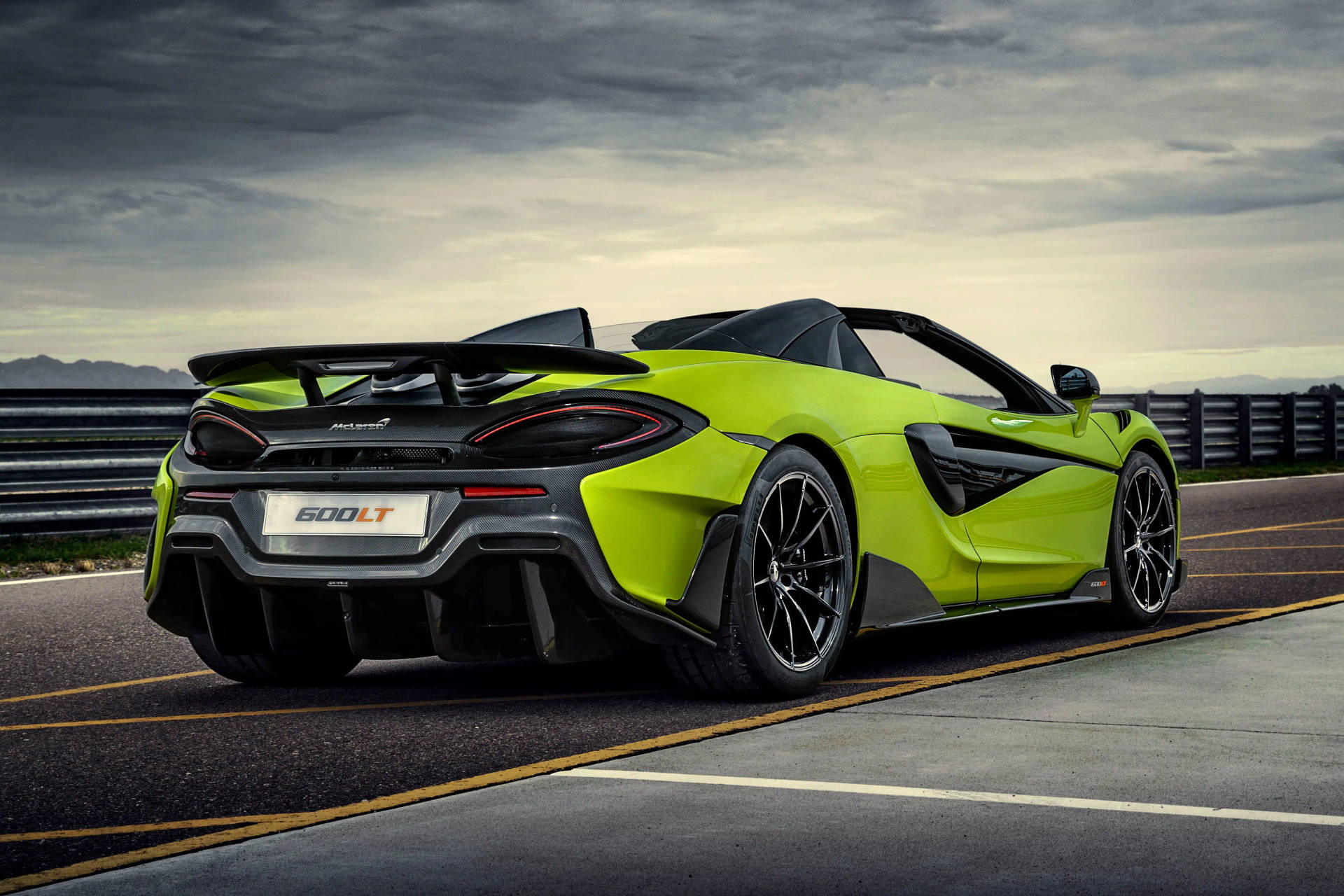 青檸綠色McLaren 600LT Spider開篷跑車在賽道上，天空多雲。