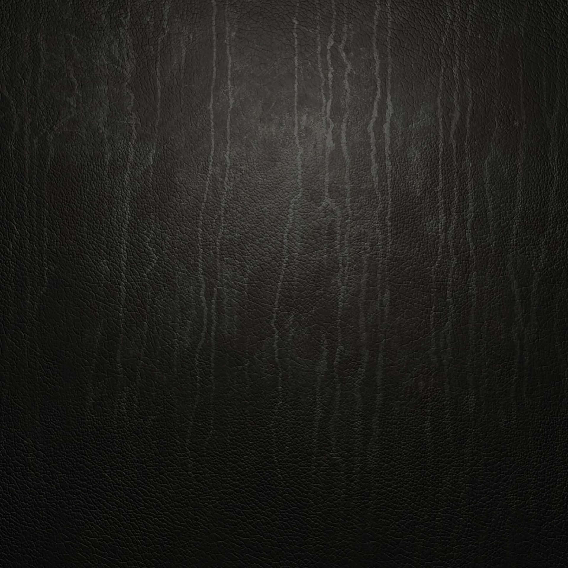 具有天然紋理和微妙皺紋的深色紋理皮革表面。