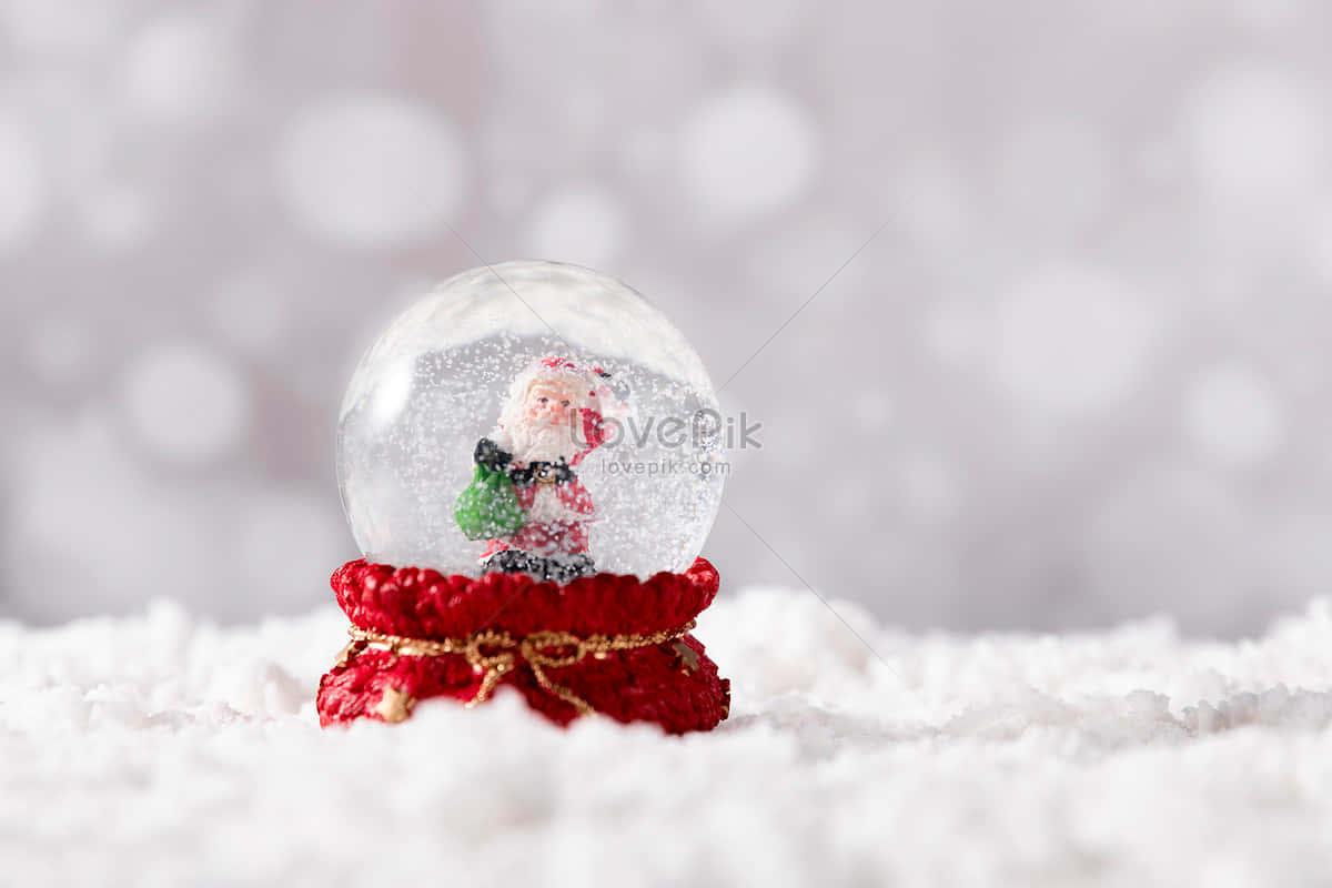 雪球內有聖誕老人公仔，放在紅色鉤針編織底座上，置於雪地表面。