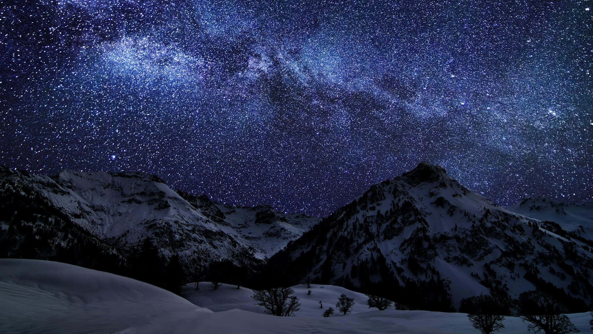 在銀河可見的 vibrant 星空夜晚下的積雪山峰。