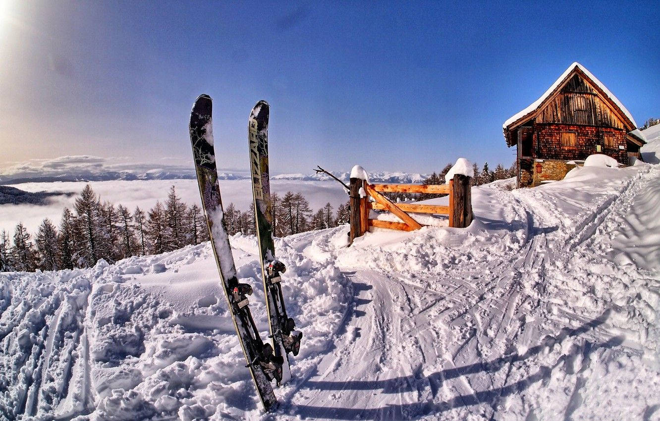 雪中的滑雪杖，靠近小屋，下方有雲