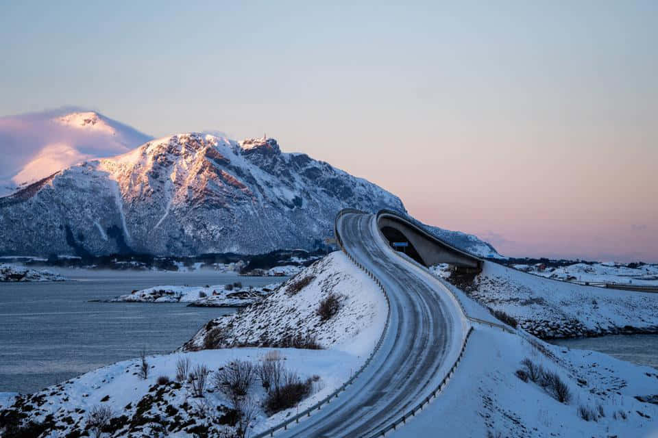 暮色中彎曲越過峽灣的積雪山路
