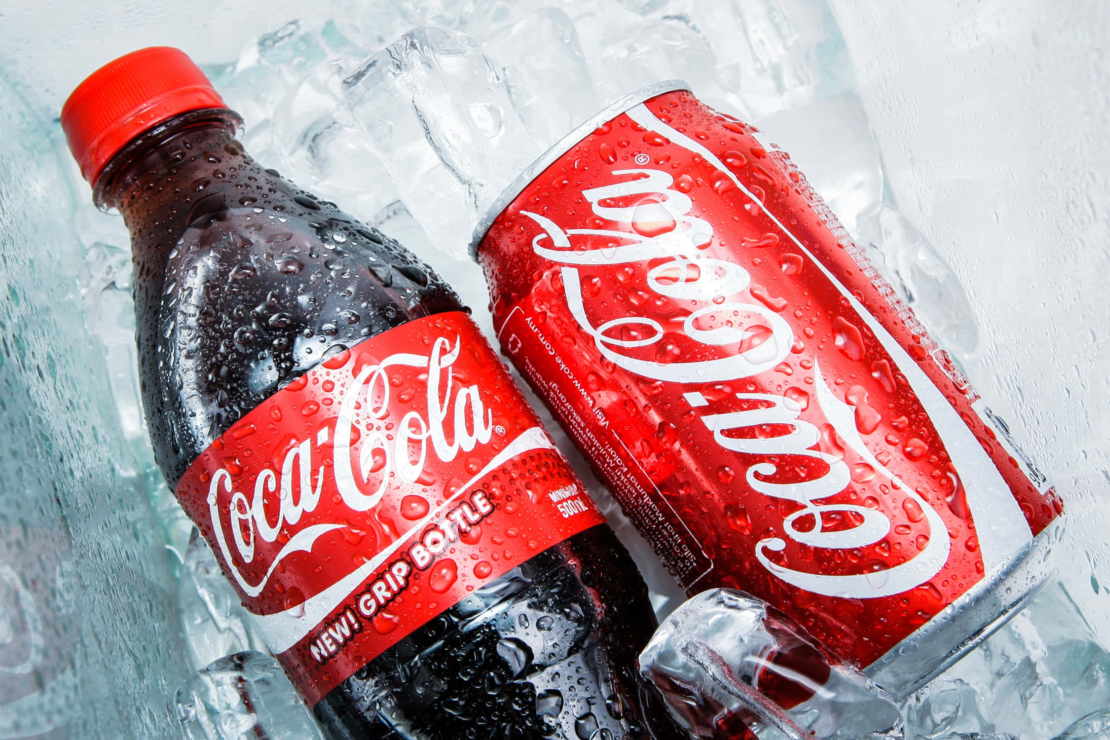 coca cola 桌布 壁紙 — 冰凍可口可樂樽及罐，置於閃爍冰塊中，帶有冷凝水滴。