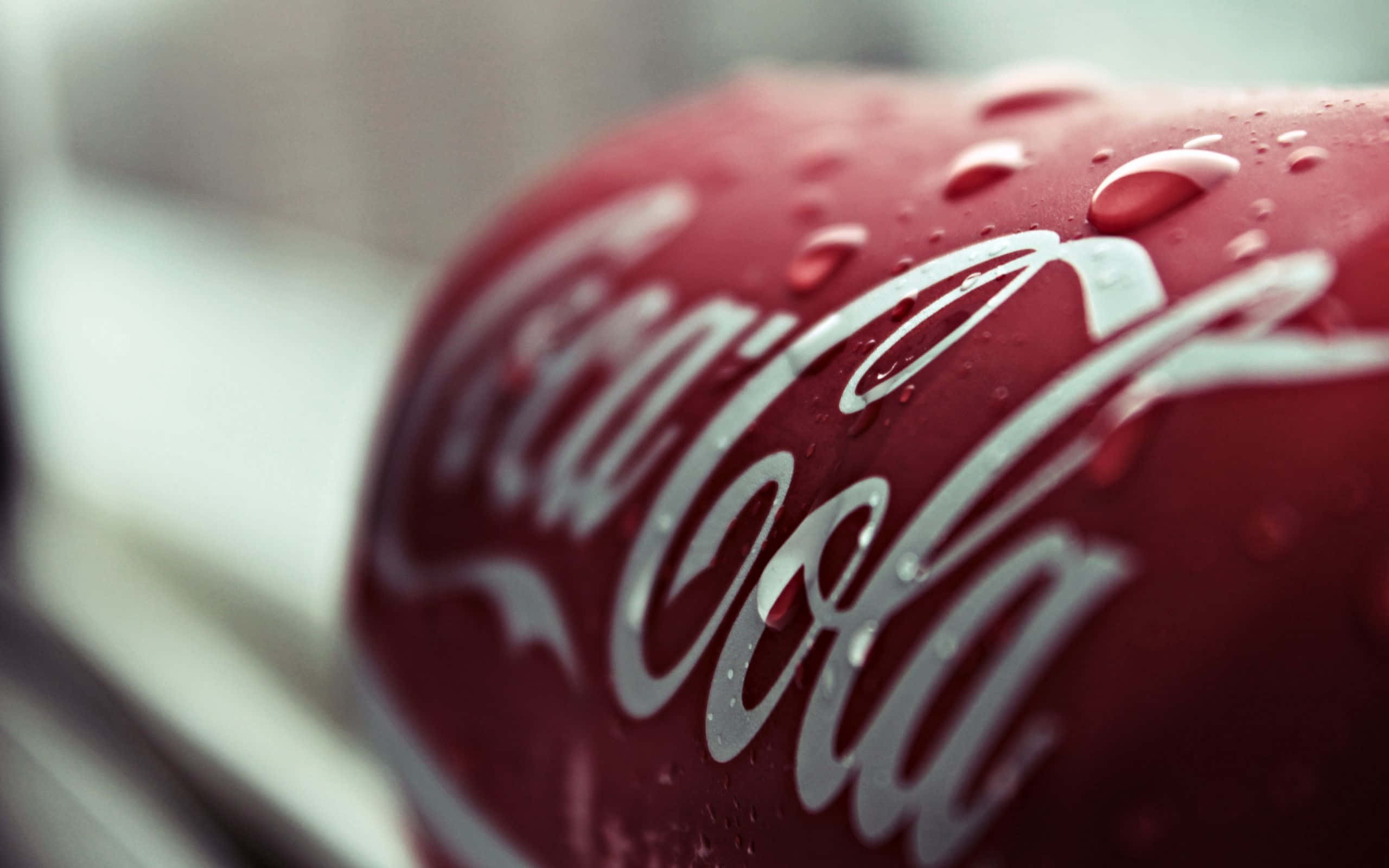 coca cola 桌布 壁紙 — 冰凍可口可樂樽的特寫，其標誌性的紅色表面上凝結的水珠閃閃發光。