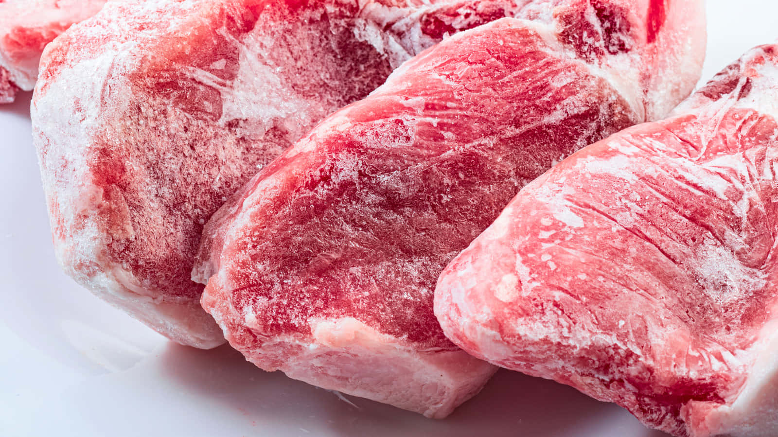 Red Meat 桌布 壁紙 — 冰凍生肉塊的特寫，鮮紅色肉上帶有霜狀白色塗層。
