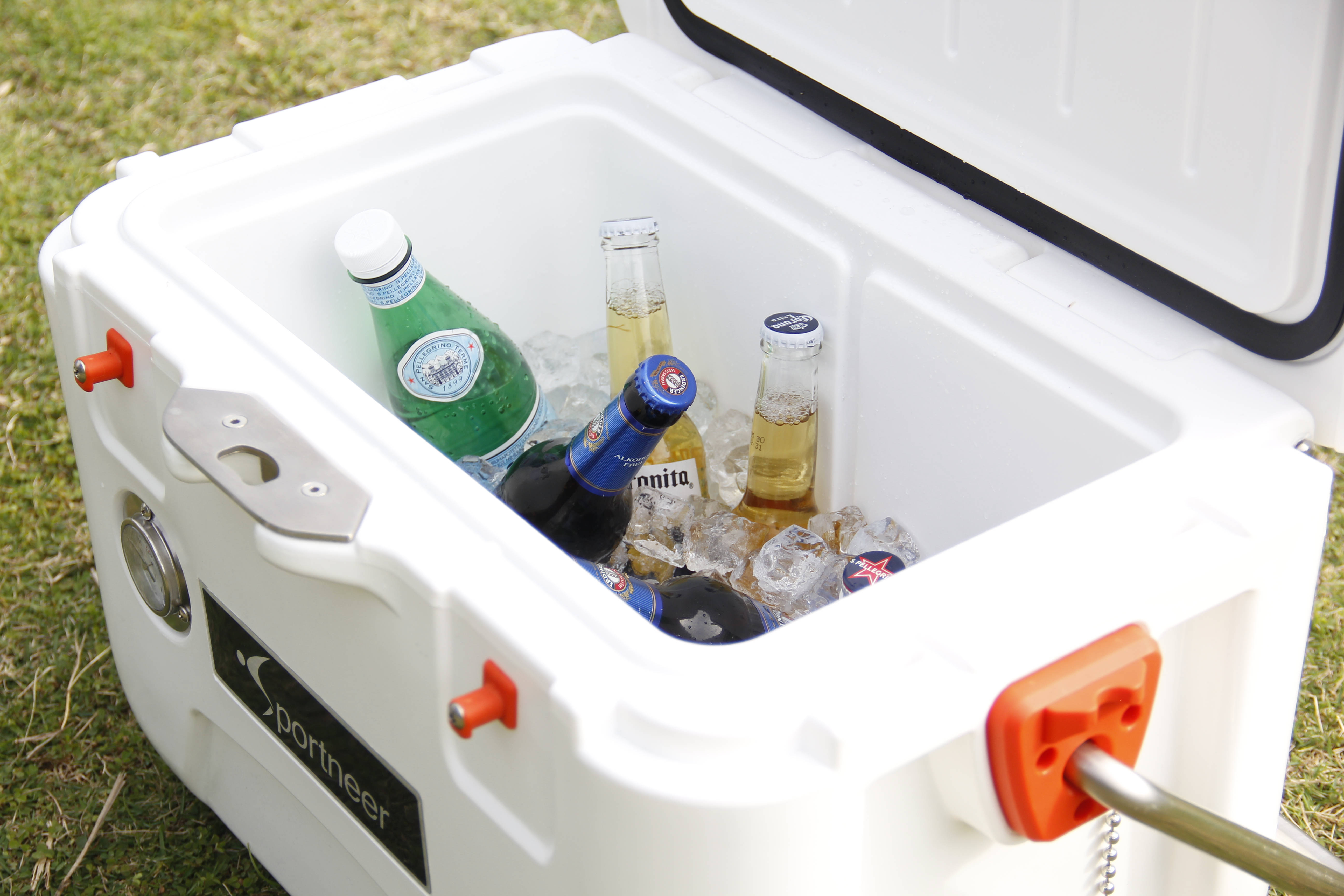 冰塊與飲料在保冰箱內 壁紙 — 一個白色Sportneer冷卻器打開放在草地上，露出冰塊和各種瓶裝飲料。