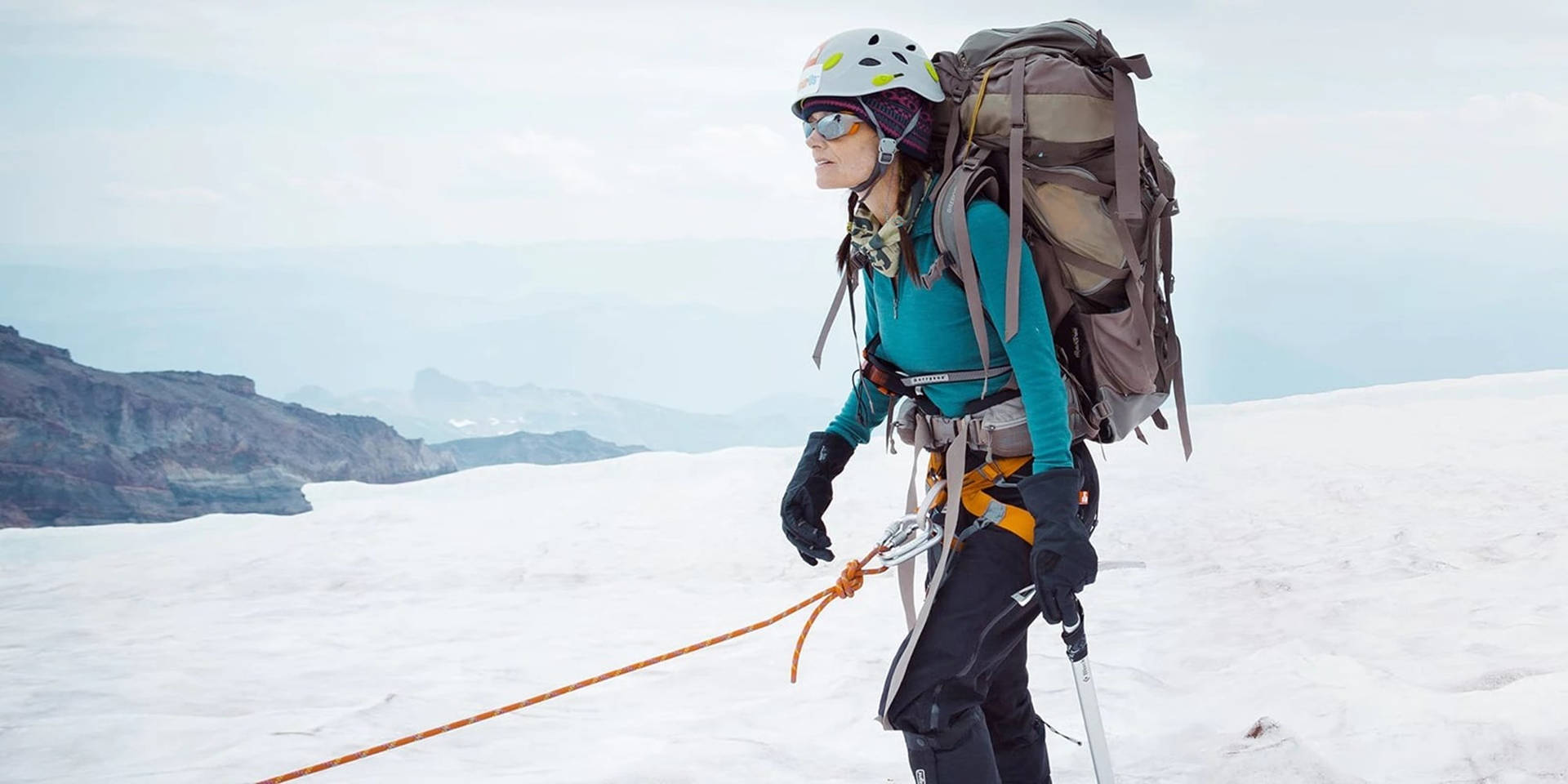 登山者用繩索和冰斧攀登積雪的山峰