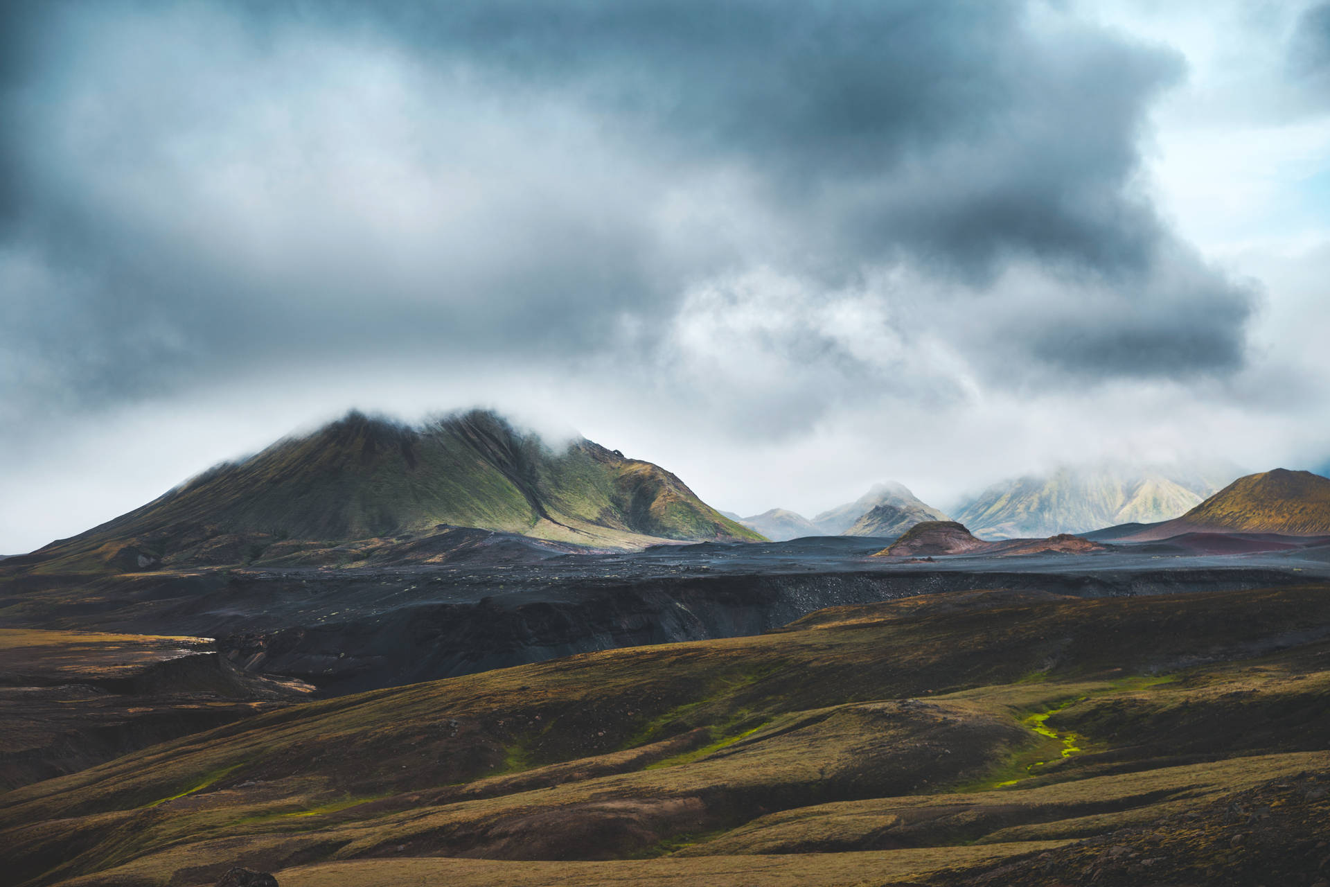 暴風雨天空下的火山山脈，帶有烏雲和崎嶇地形。