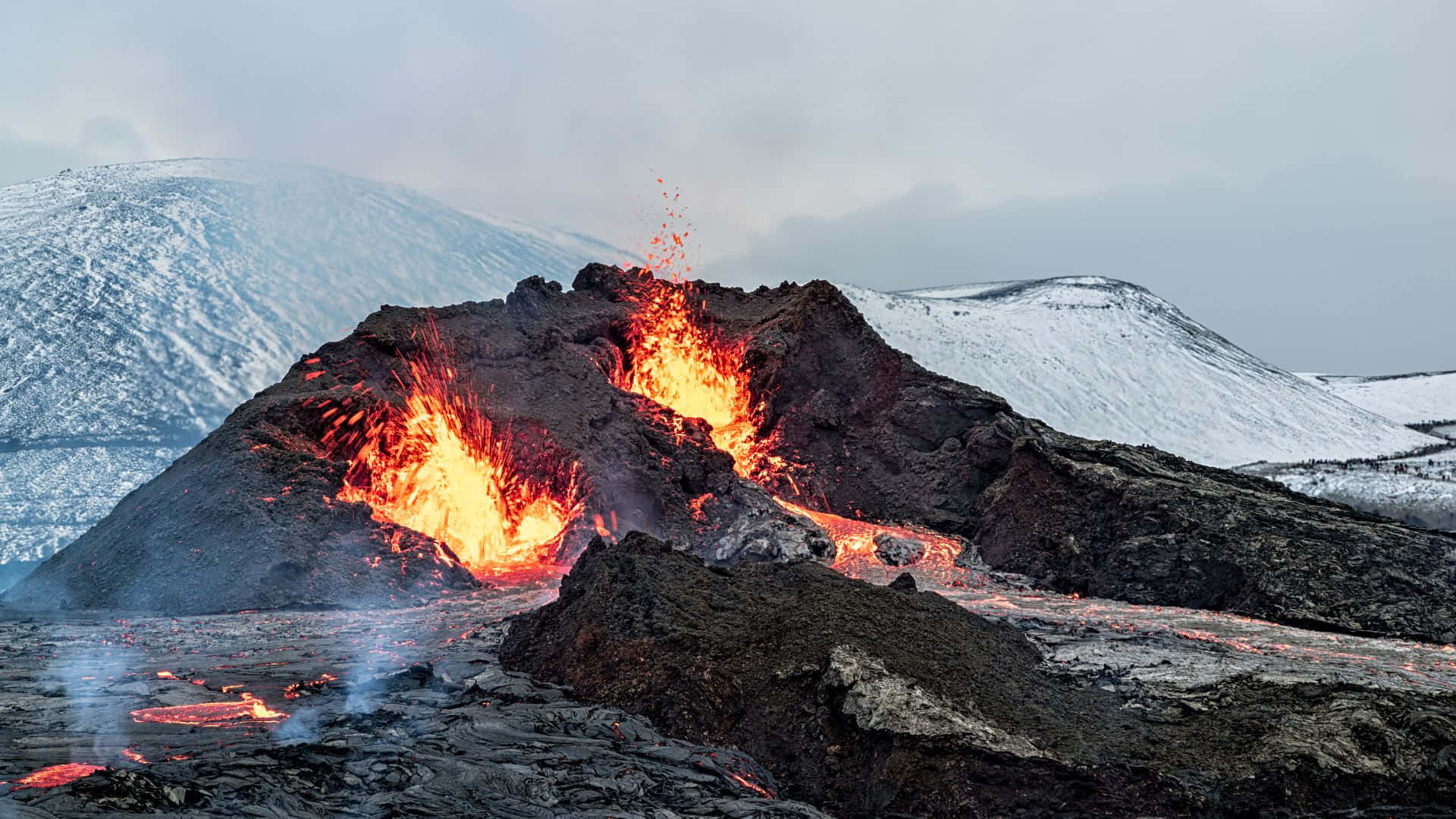 火山爆發，熔岩流經雪山。