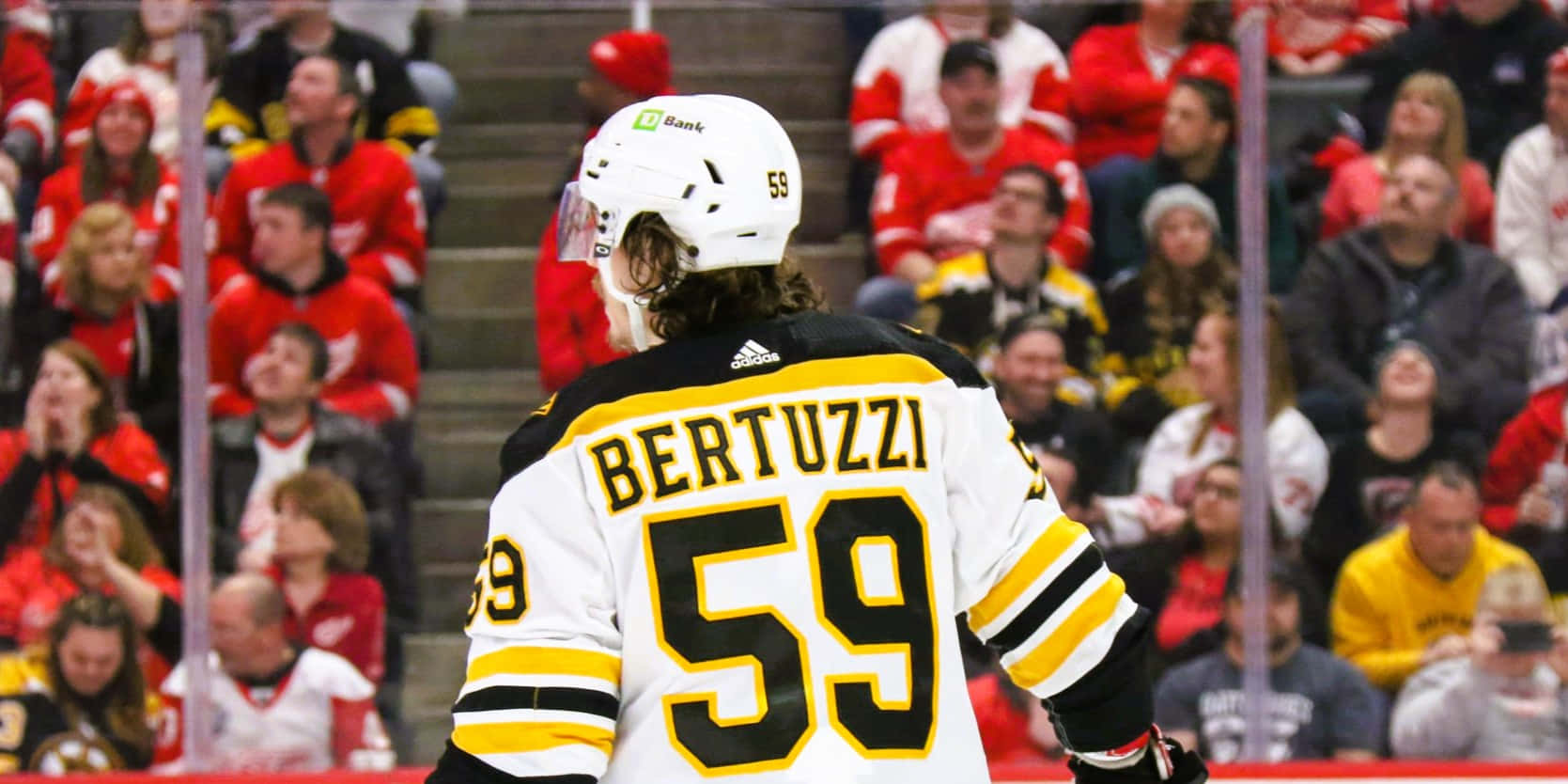 Tyler Bertuzzi 桌布 壁紙 — 冰球運動員Bertuzzi身穿白色和黃色59號球衣，站在冰面上，背景有觀眾。