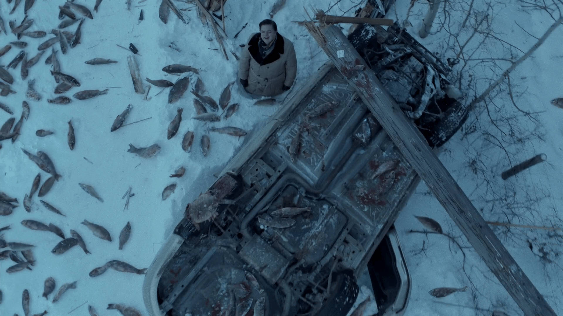 一個人站在雪地裡一輛裝滿魚的破車旁邊。