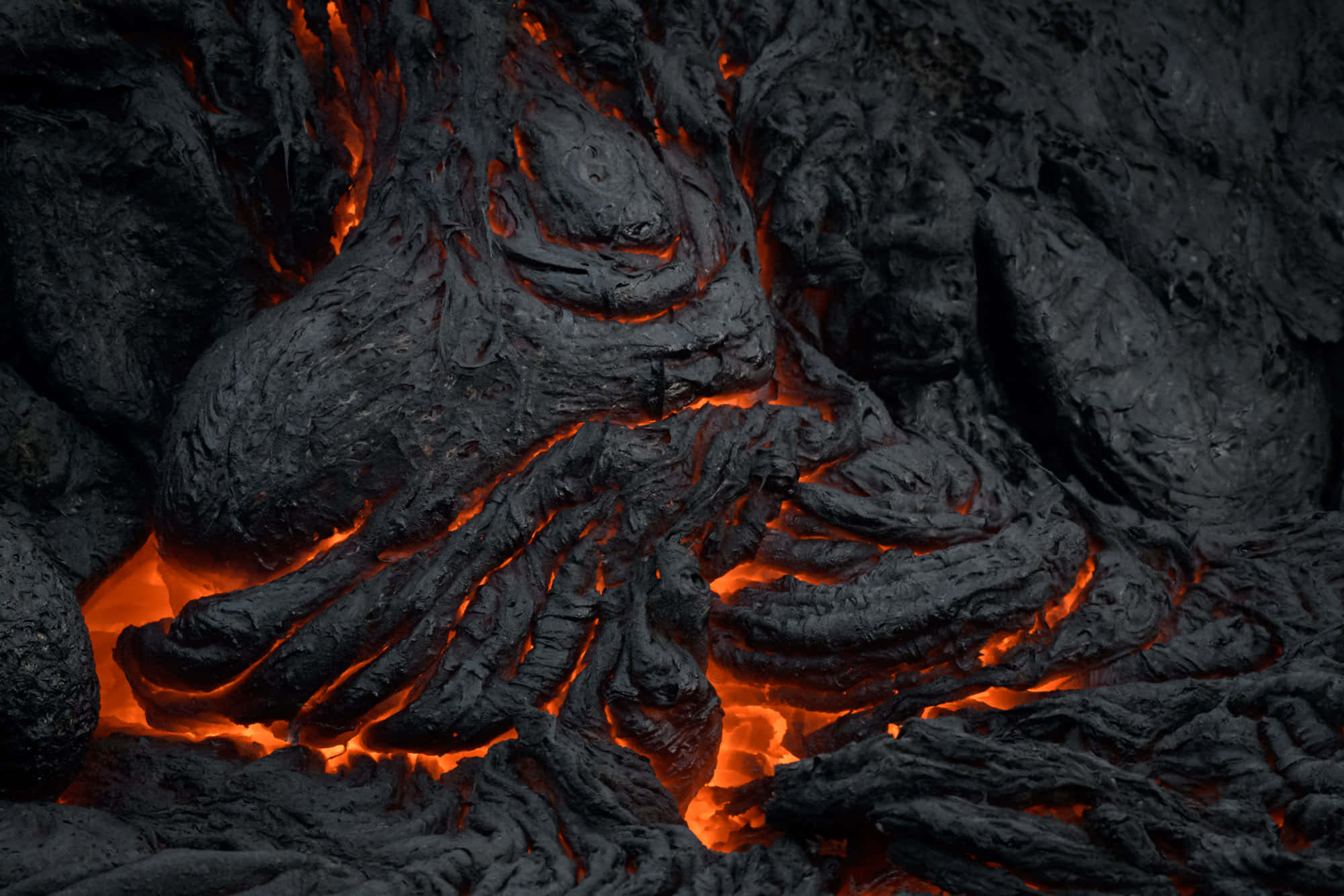 lava 桌布 壁紙 — 冷卻熔岩的特寫，發光的橙色熔岩在黑暗崎嶇的地殼下流動。