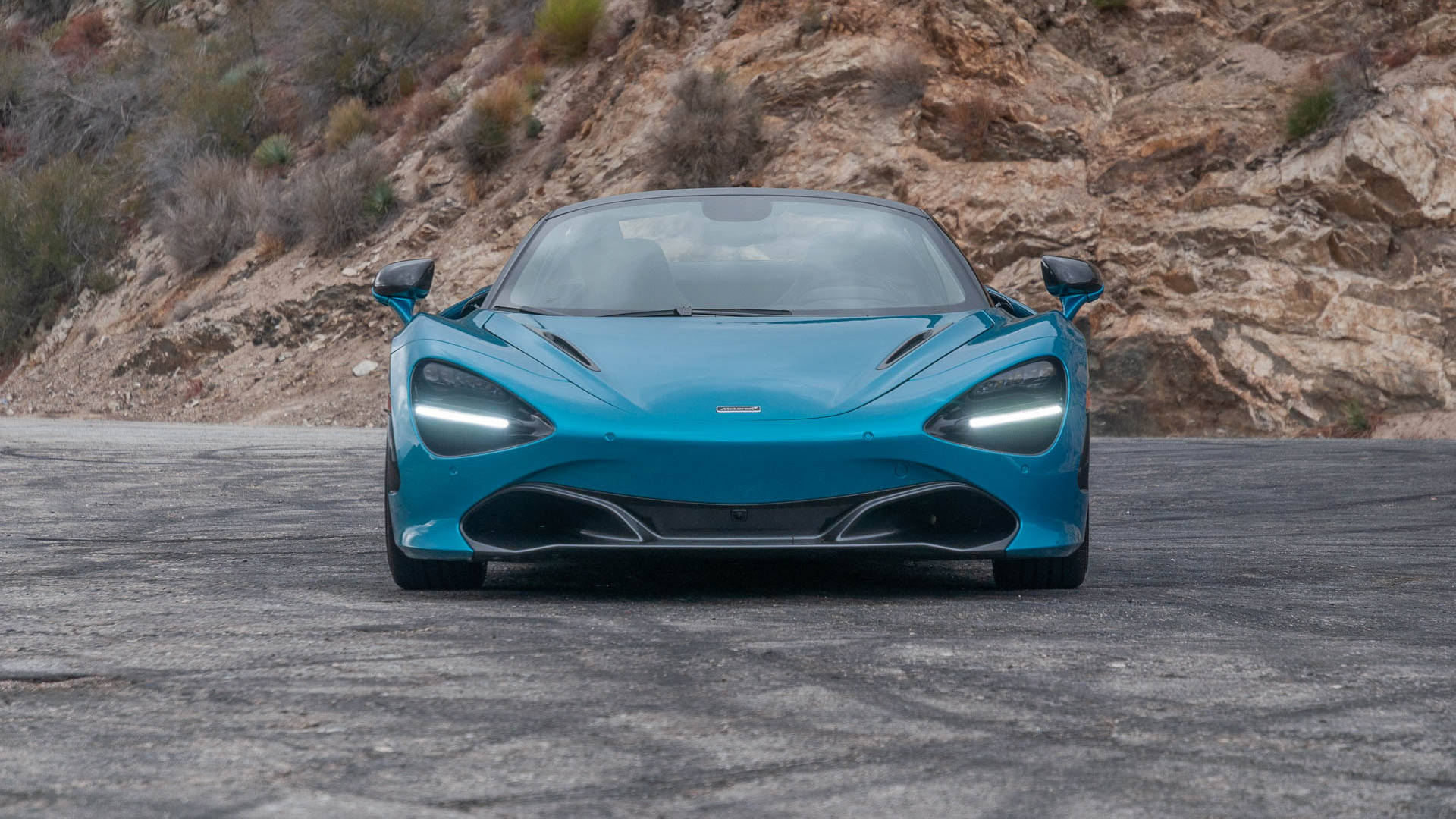 青綠色McLaren 720S跑車在山路上。