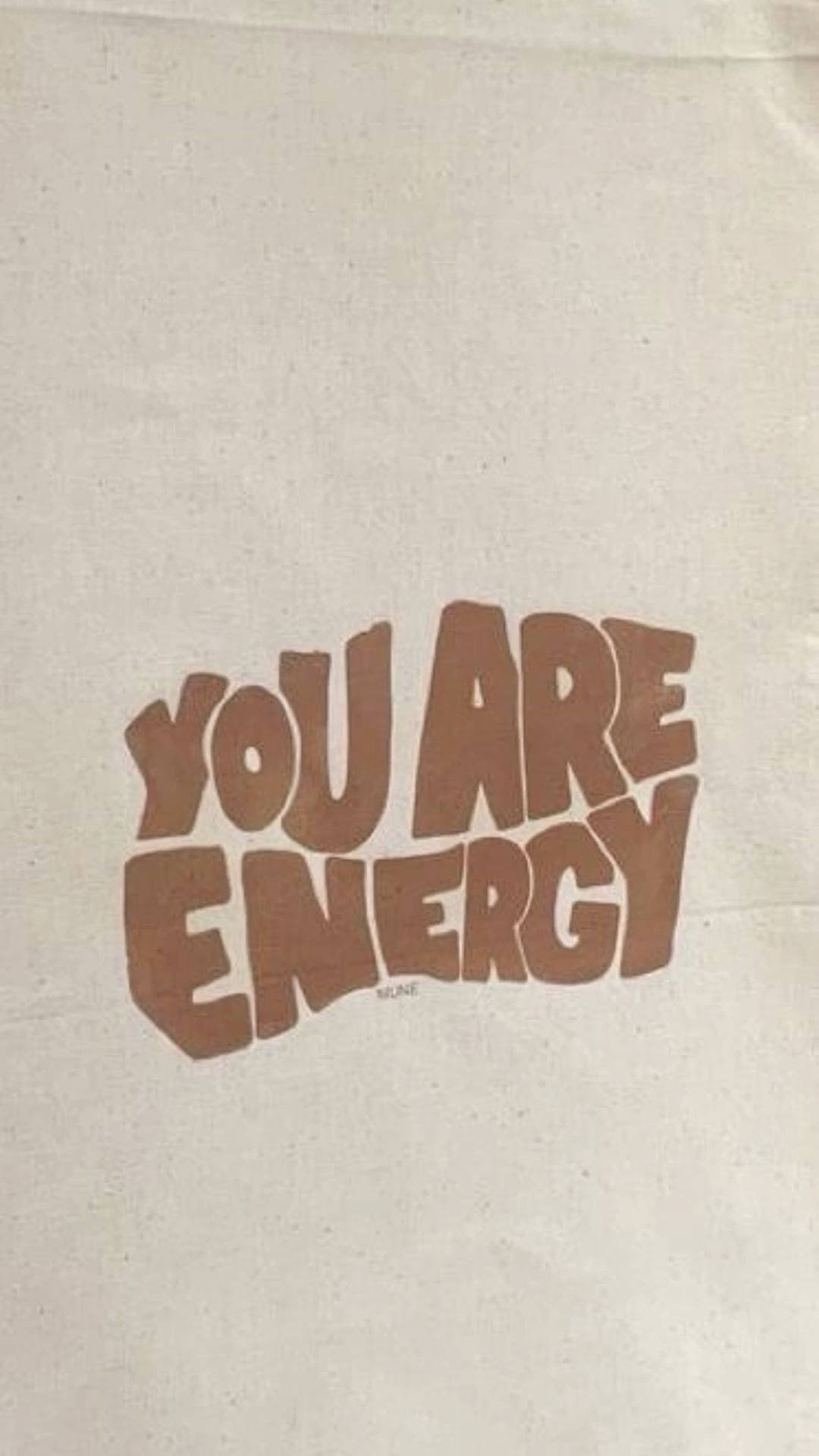 文字牆紙，上面以復古字體印有 'YOU ARE ENERGY' 的棕色文字在米白色布料上。