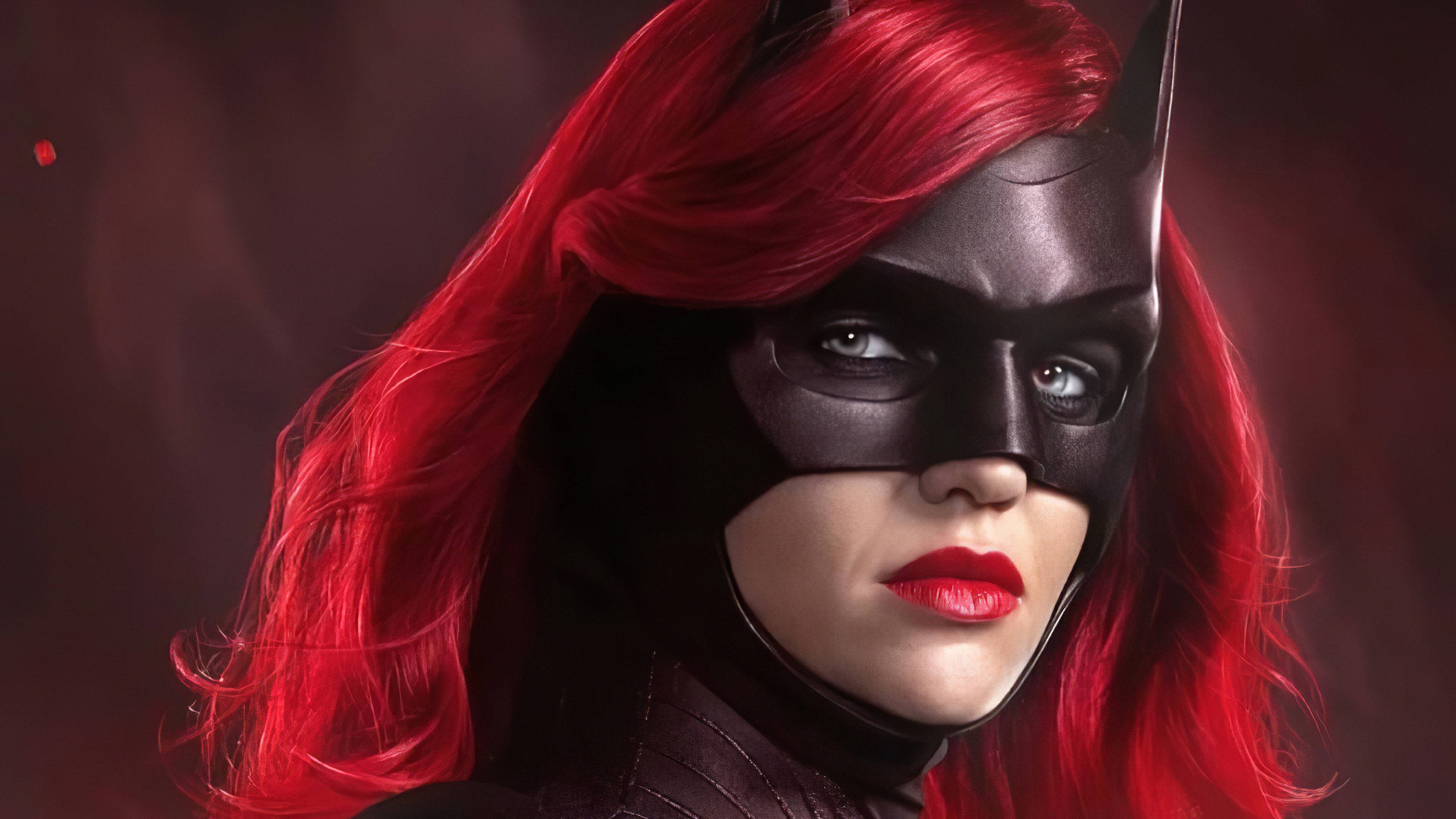 冷酷 Batwoman Ruby Rose 壁紙 — 一張引人注目的貓女肖像，擁有鮮豔的紅髮和大膽的紅唇，背景陰暗而富有氣氛。