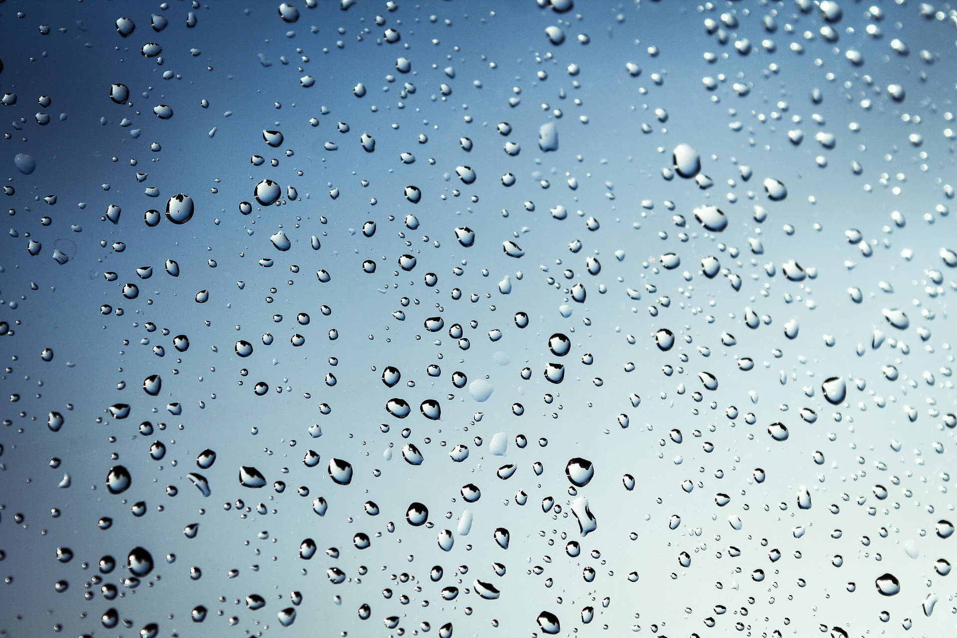 玻璃上的雨滴反射藍天
