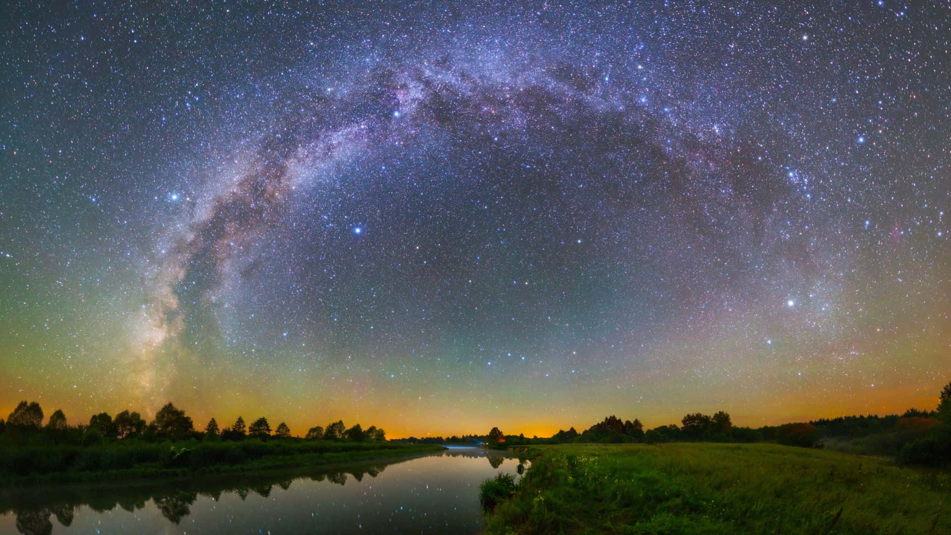 在星空下，銀河系反射在平靜的河流中。
