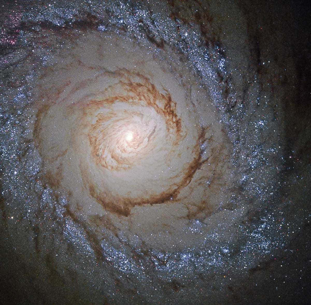 凝望美麗銀河 壁紙 — 一個令人嘆為觀止的螺旋星系，擁有發光的橙色核心和由恆星與宇宙塵埃組成的旋轉臂，背景是黑暗虛空。