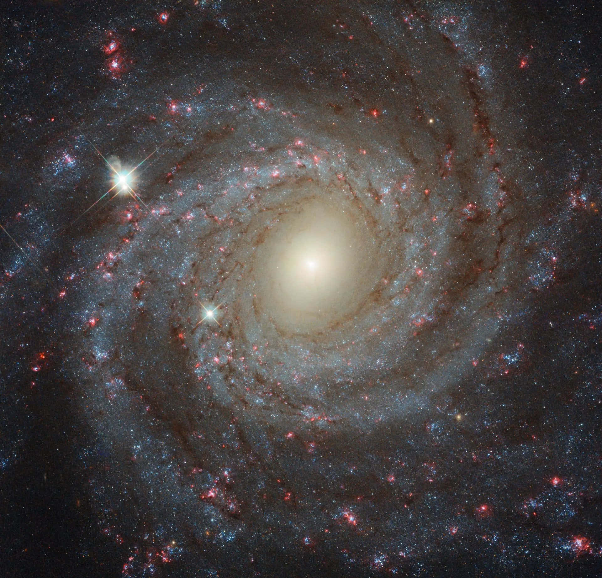 凝視宇宙深處 壁紙 — 一個令人驚嘆的螺旋星系，帶有發光的旋臂和明亮的恆星在深空中旋轉。