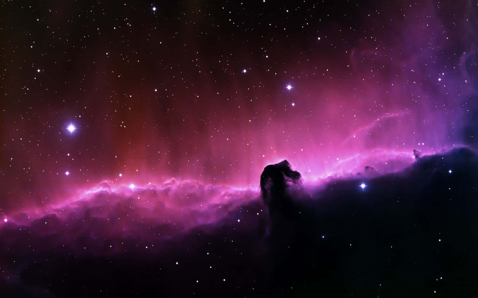 鮮豔的紫色和紅色星雲，帶有星星和一個黑色宇宙柱剪影。