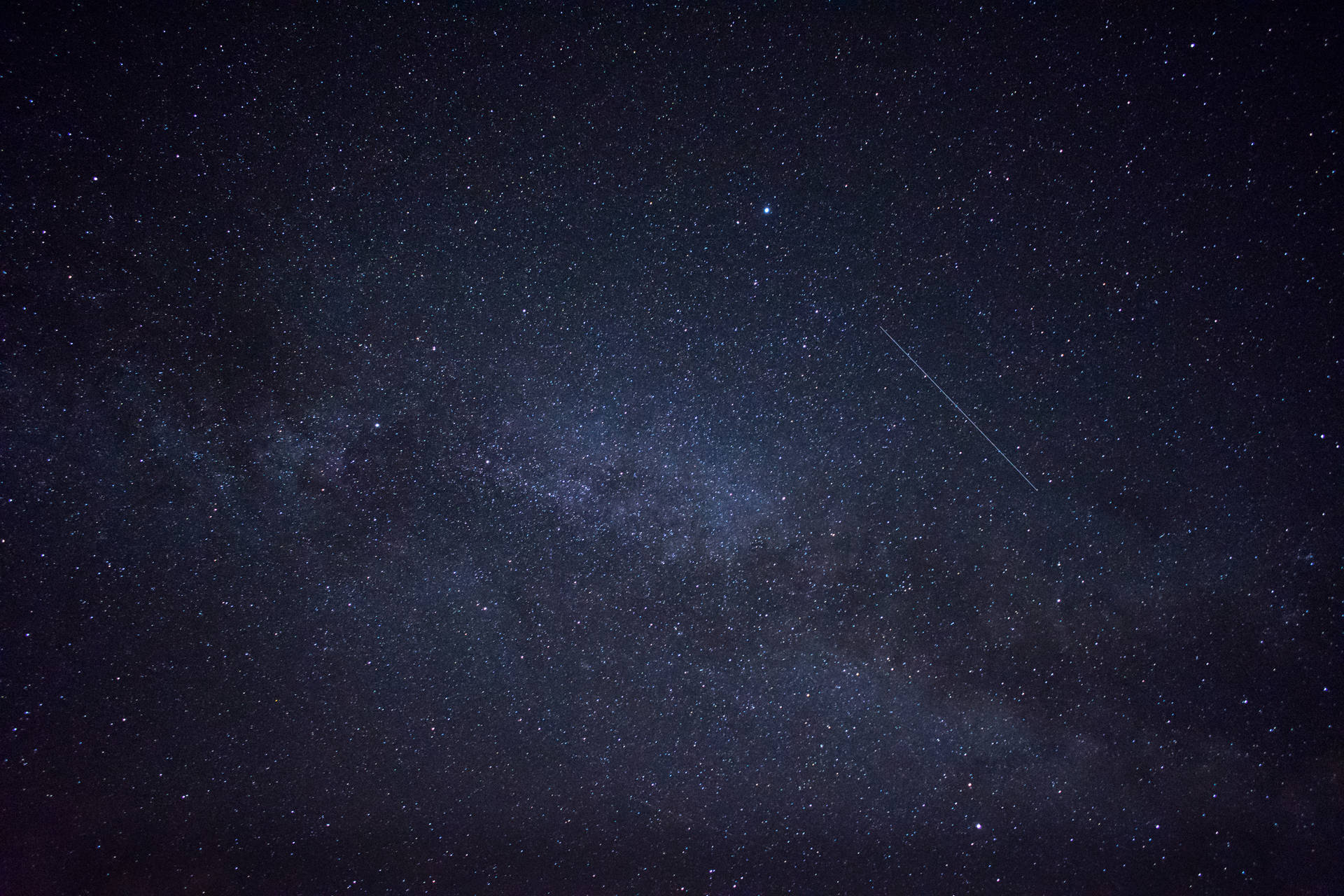 銀河系與流星在繁星點點的夜空中。