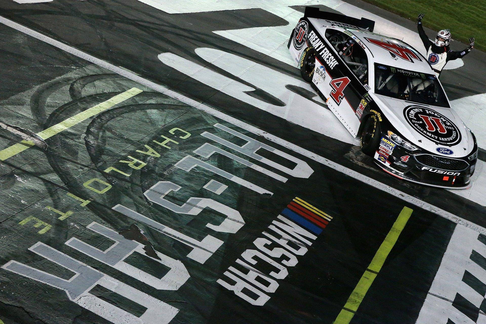NASCAR賽車越過終點線，車手在夜間慶祝勝利。