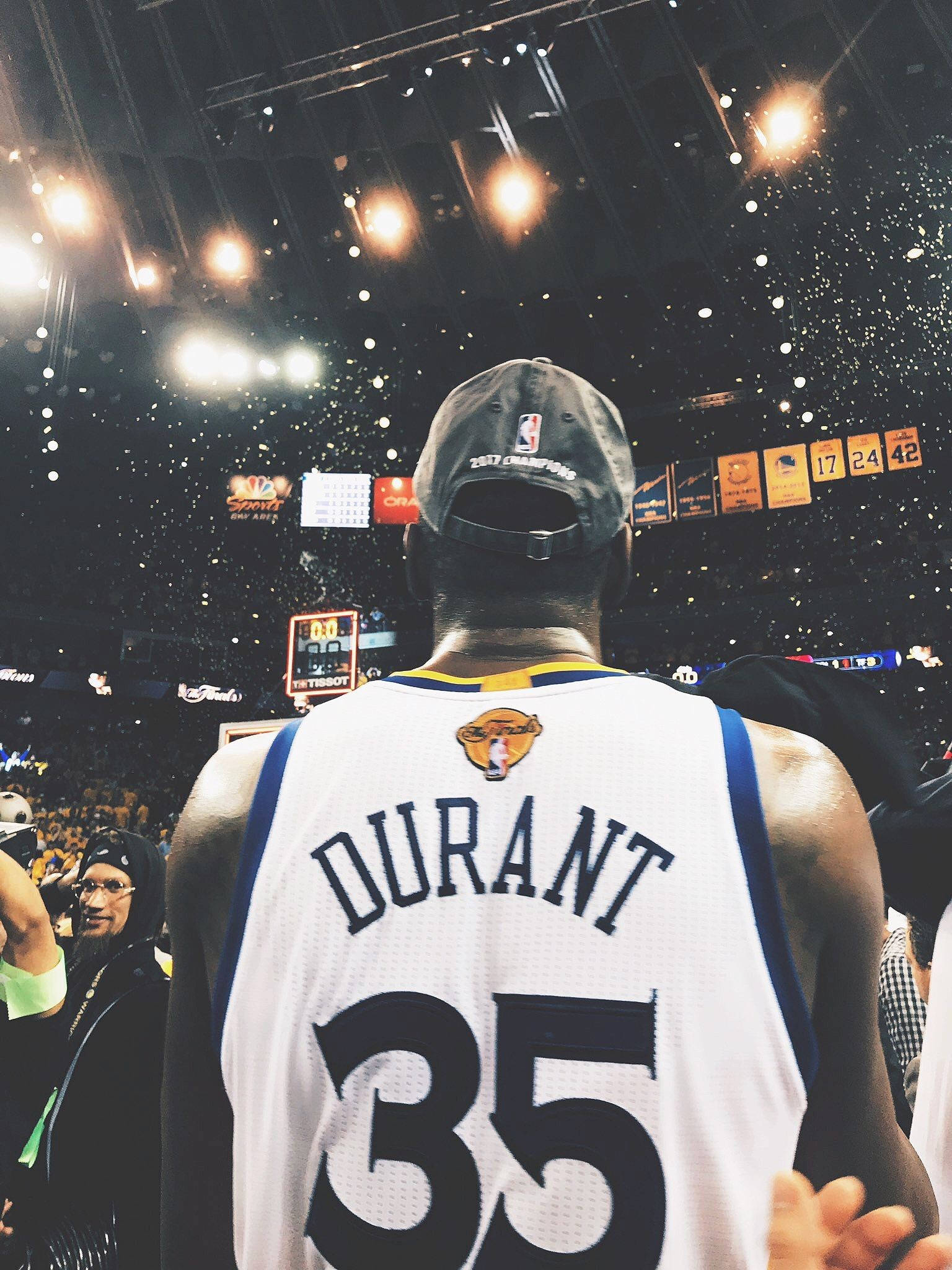 凱文·杜蘭特美學背影壁紙 壁紙 — 一名身穿 'DURANT 35' 球衣的籃球運動員背對鏡頭站立，在擠滿觀眾的場館中，彩紙紛飛。