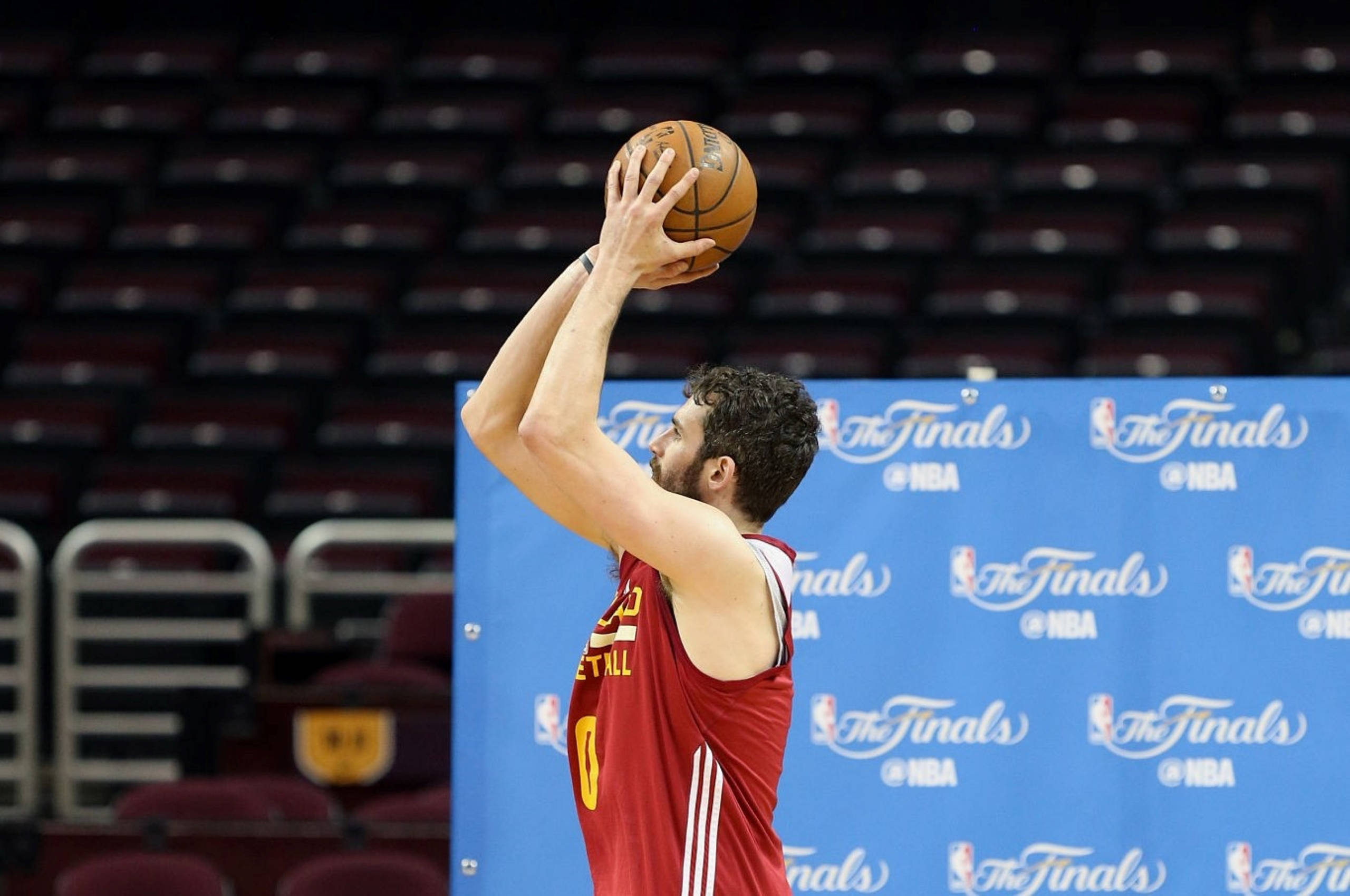 凱文·樂夫 2016 NBA總決賽 壁紙 — 一名身穿紅色球衣的籃球運動員在空蕩的球場上，準備在藍色總決賽背景下投籃。
