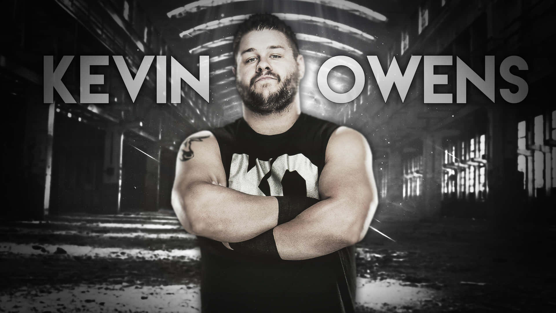 凱文·歐文斯 摔角手海報 壁紙 — Kevin Owens 自信地交叉雙臂，站在一個粗糙、單色的工業走廊中，光線戲劇性。