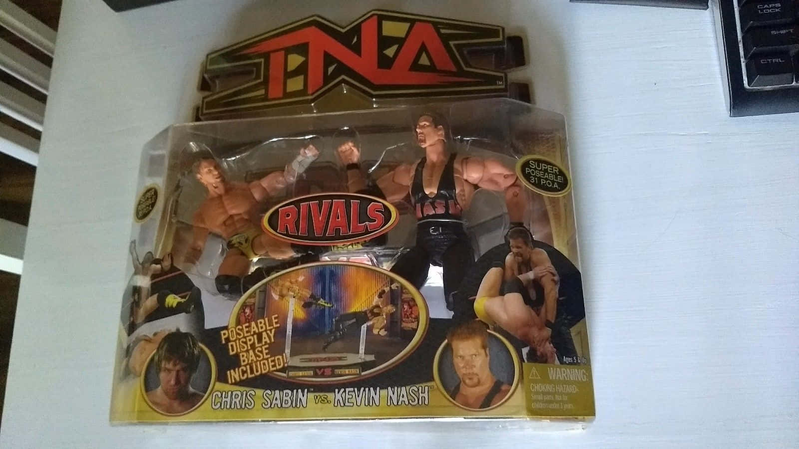 包裝在白色表面上的TNA Rivals摔角人偶Chris Sabin和Kevin Nash。