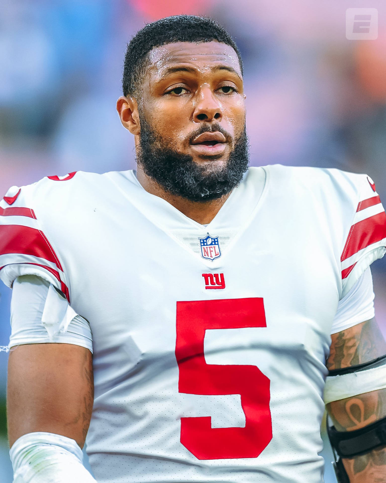 身穿白色球衣、紅色五號的NFL美式足球員，神情專注。