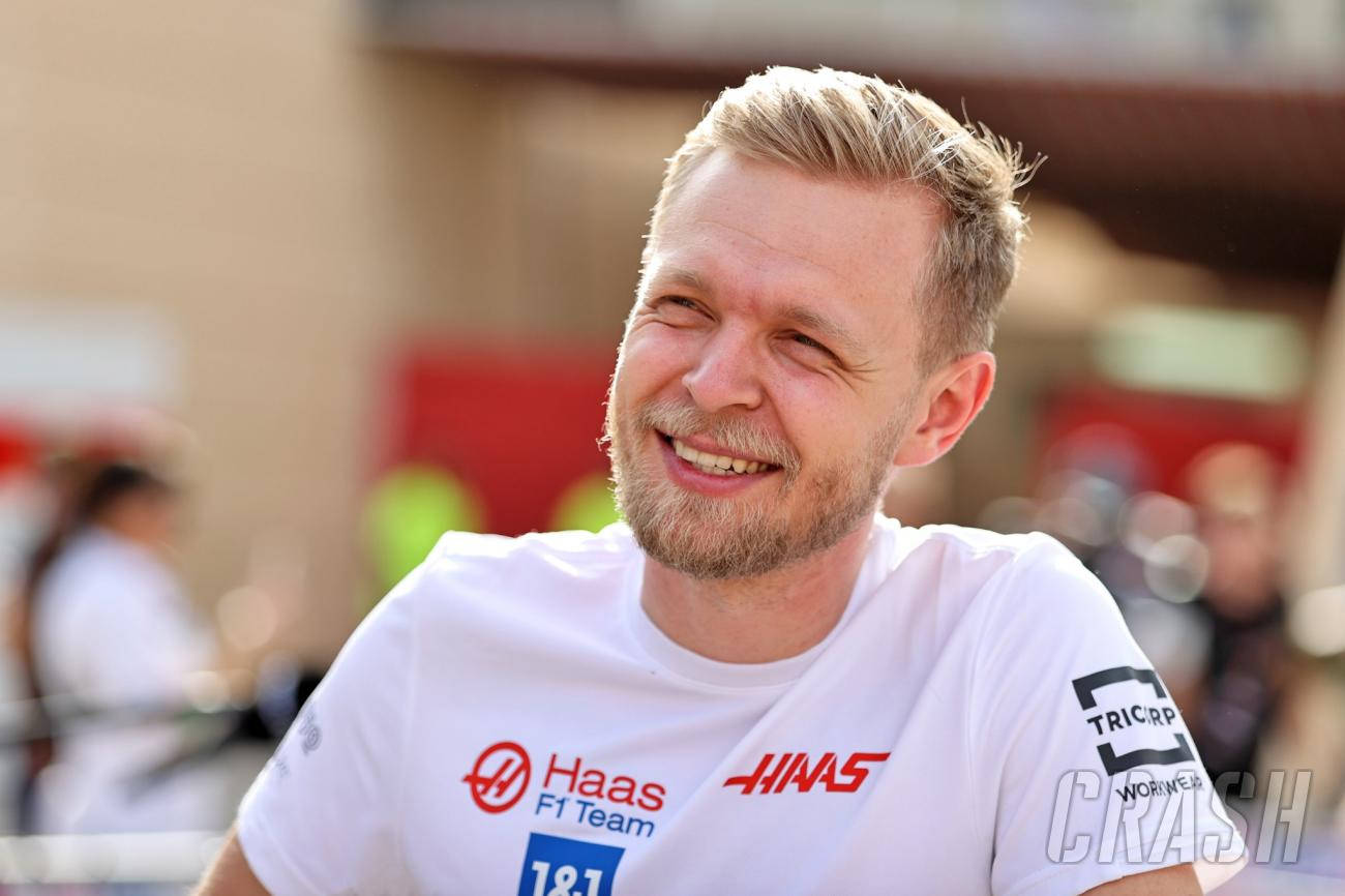 金髮鬍鬚男士微笑著穿著Haas F1 Team T恤。