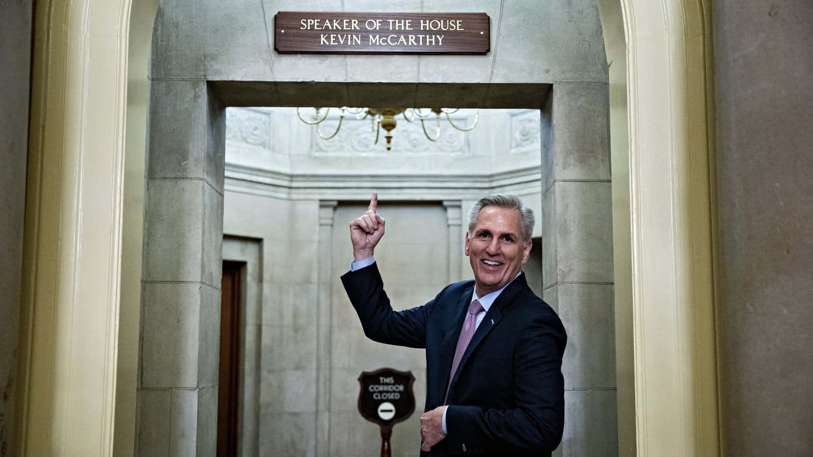 身穿西裝的凱文·麥卡錫在政府走廊中，在「Speaker of the House」標誌下向上指。
