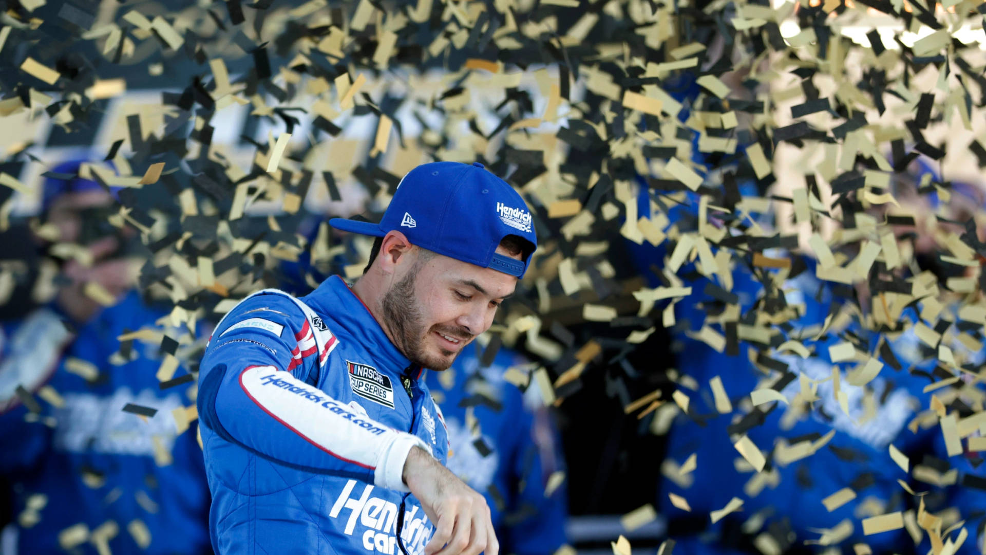賽車手在紙屑飄落中慶祝勝利。