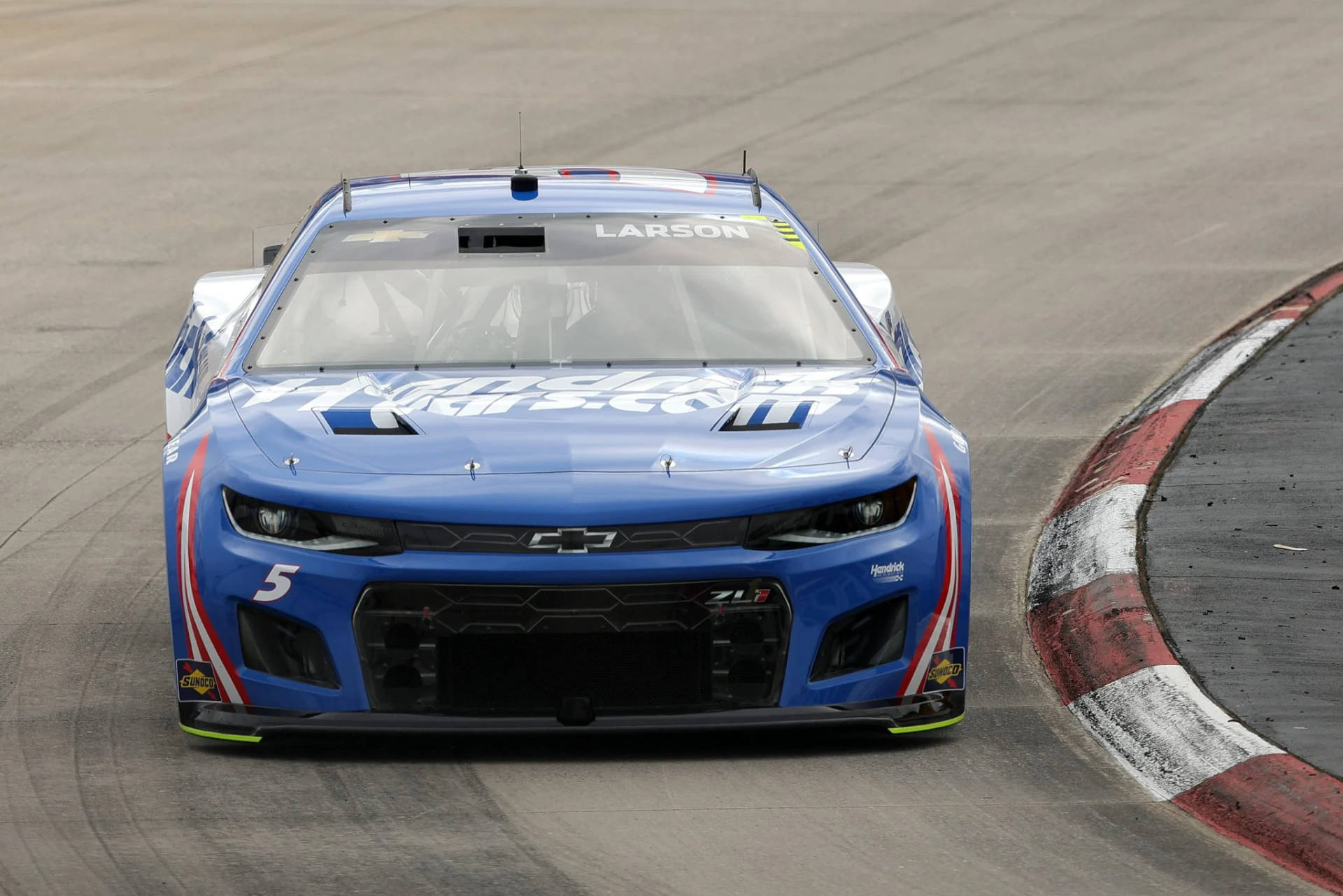 藍色NASCAR賽車編號5在賽道彎位行駛。