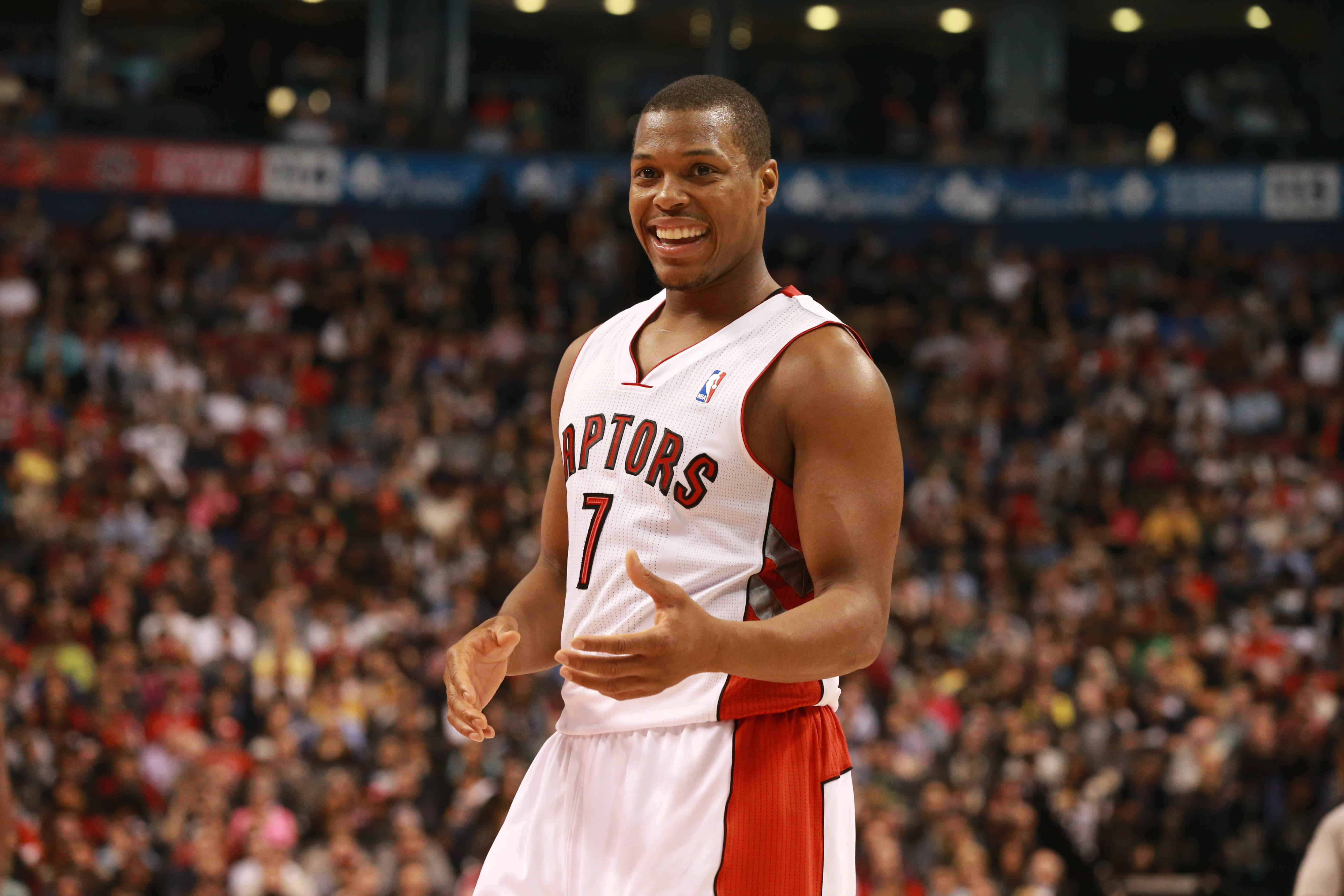 凱爾·洛瑞2015年NBA全明星賽 壁紙 — 一位微笑的多倫多速龍籃球運動員，身穿白色和紅色7號球衣，在比賽中向人群做手勢。