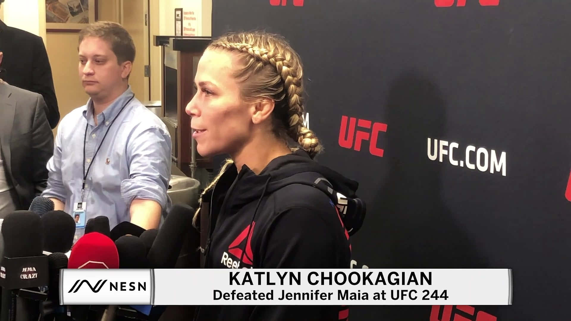凱特琳·丘卡吉安賽後訪問 壁紙 — UFC拳手Katlyn Chookagian在記者會上，於帶有品牌背景和咪高峰的環境中，賽後向傳媒發言。