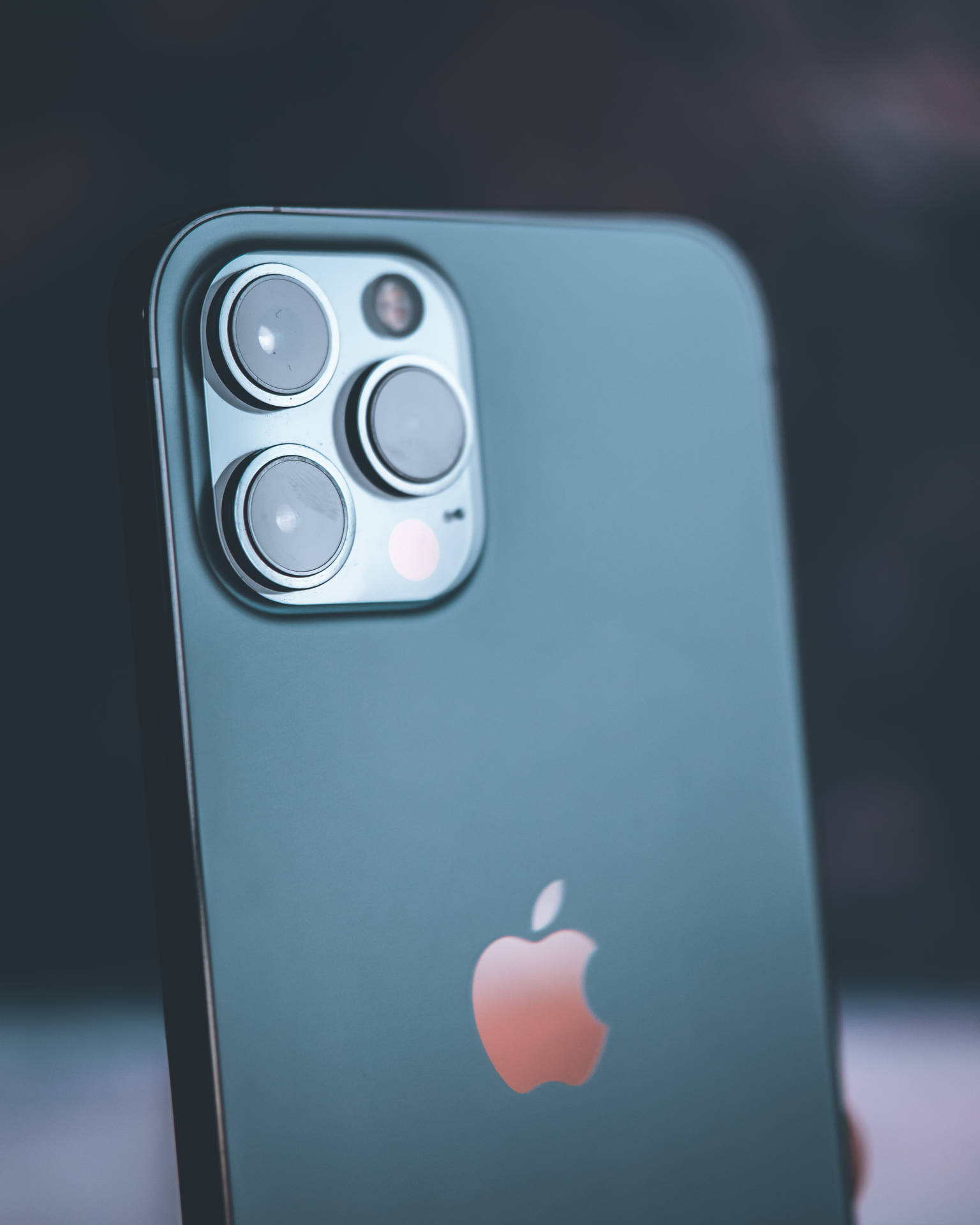 青綠色iPhone 14 Pro，帶有相機模組和發光的蘋果標誌。