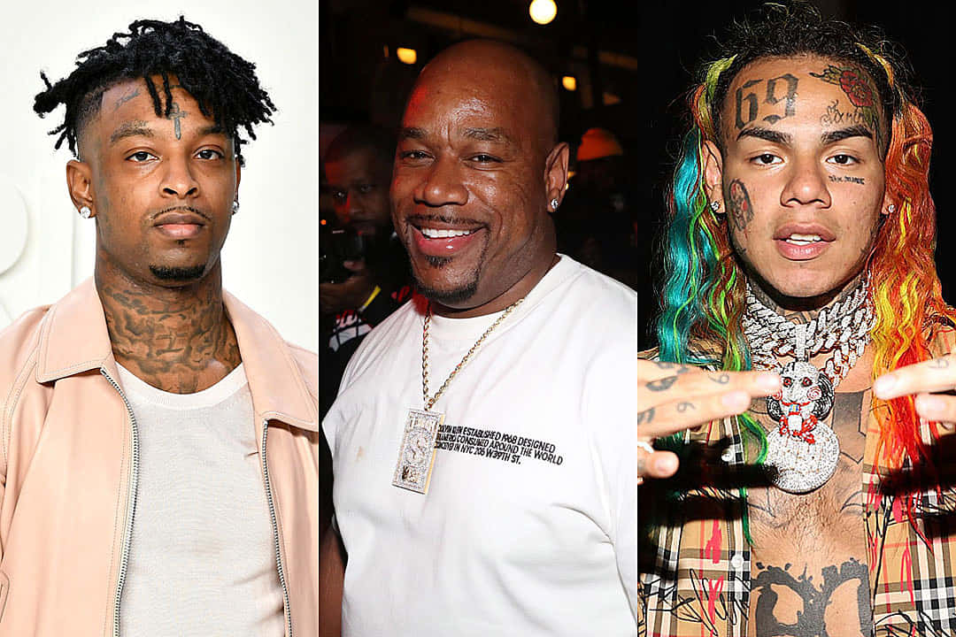 出身倫敦的嘻哈藝術家21 Savage 壁紙 — 三名有紋身和獨特髮型的男子在昏暗的室內環境中擺姿勢拍照。