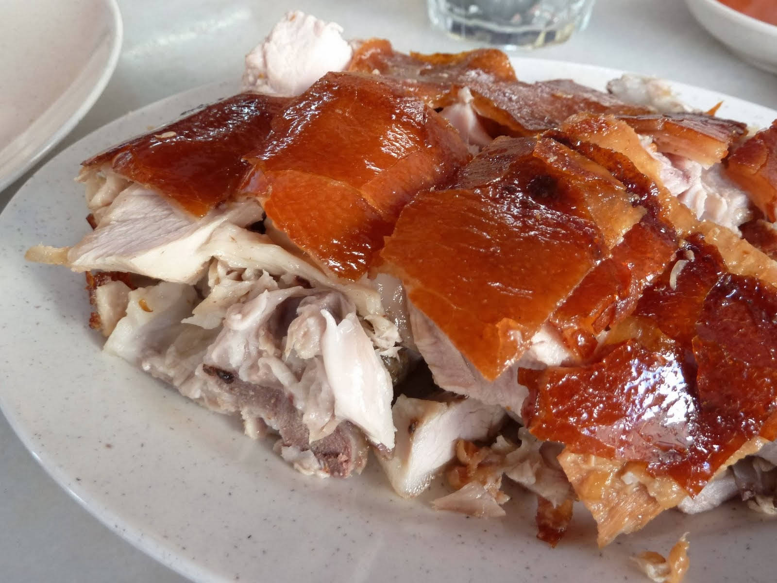 切塊豬腩肉 壁紙 — 脆皮金黃烤鴨皮在斑點碟上的嫩白肉上閃閃發光。