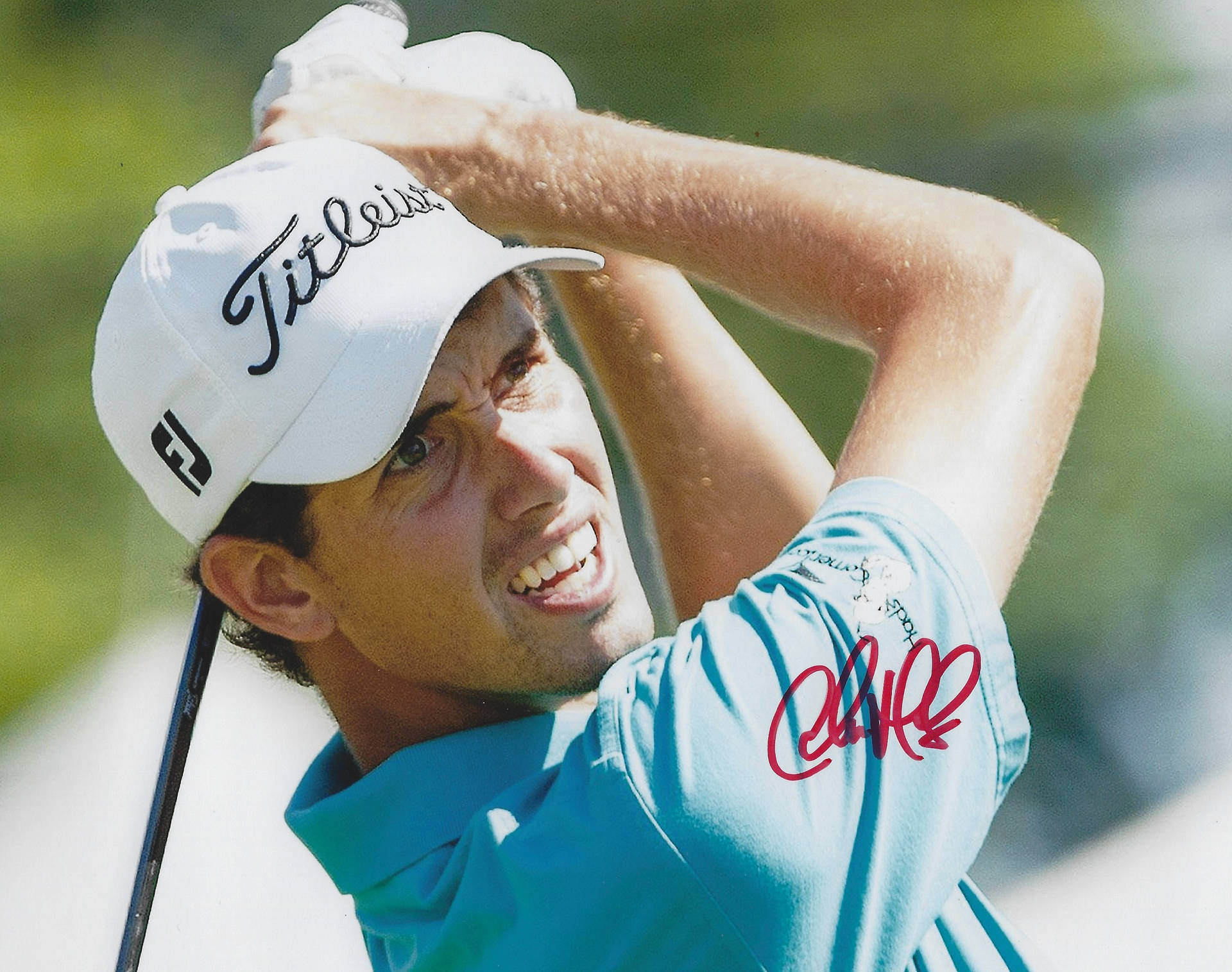 Rory McIlroy穿著藍色衫和白色帽，在揮桿時簽名。