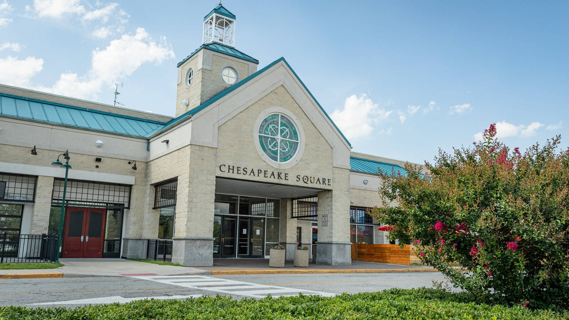 Chesapeake Square 購物中心，米色石牆和粉紅色開花灌木。