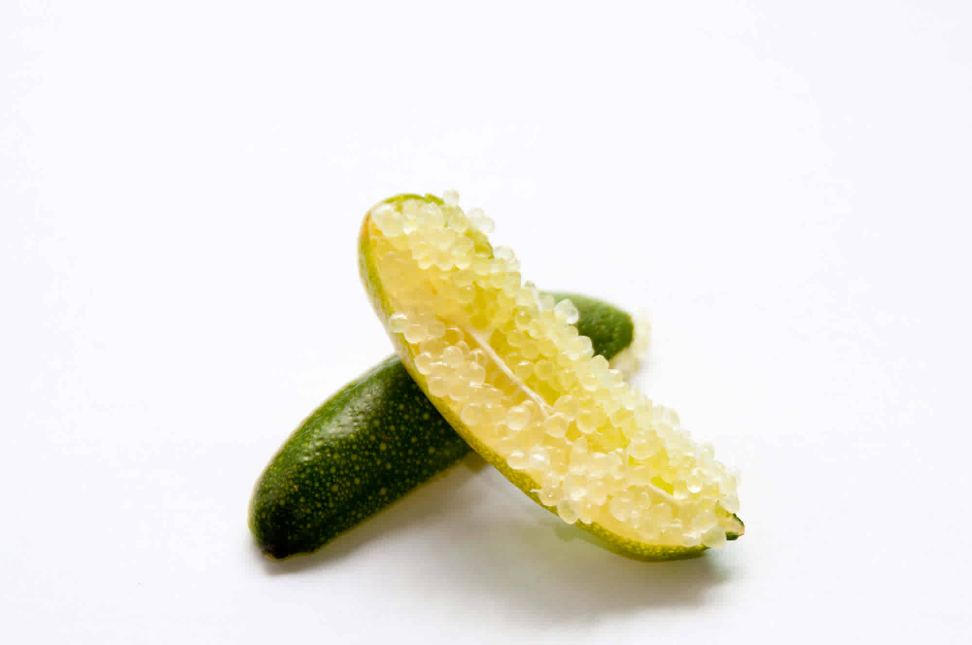 切開的指 lime 壁紙 — 切片金橘露出閃閃發光的半透明種子，背景為純白色。