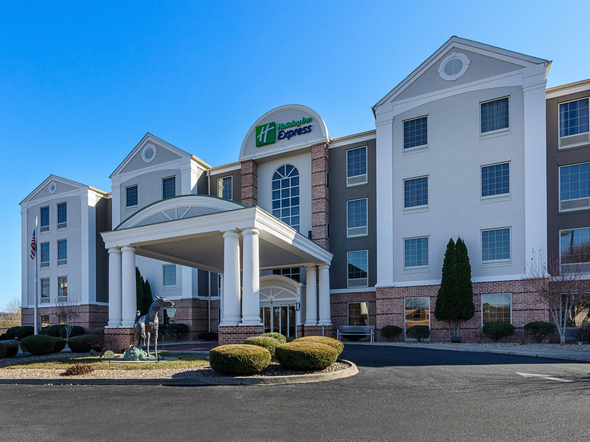 Holiday Inn Express 酒店，白色柱子和磚塊外牆，藍天之下。