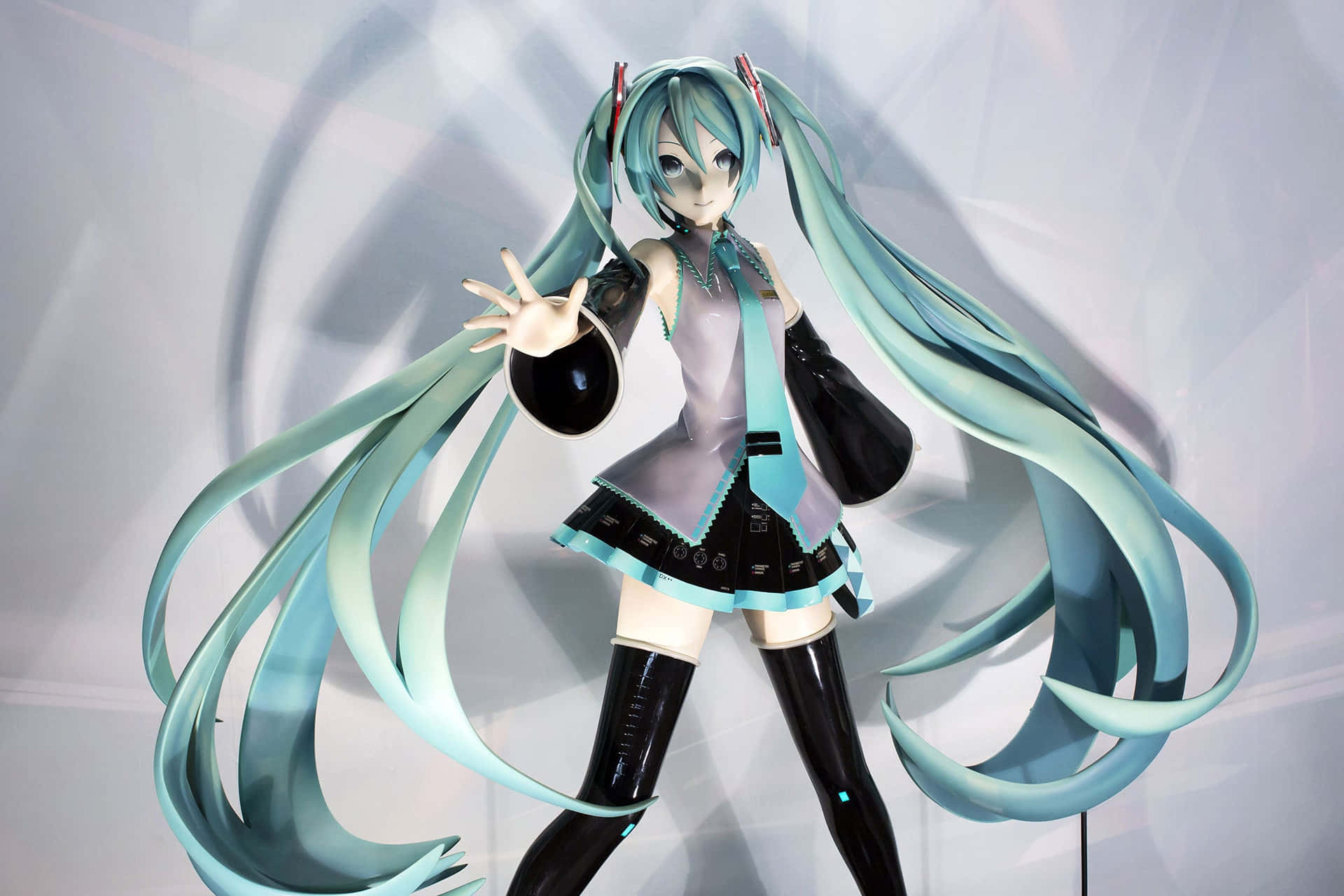 動漫角色人偶初音未來，擁有藍綠色頭髮和黑色服裝，正在擺姿勢。